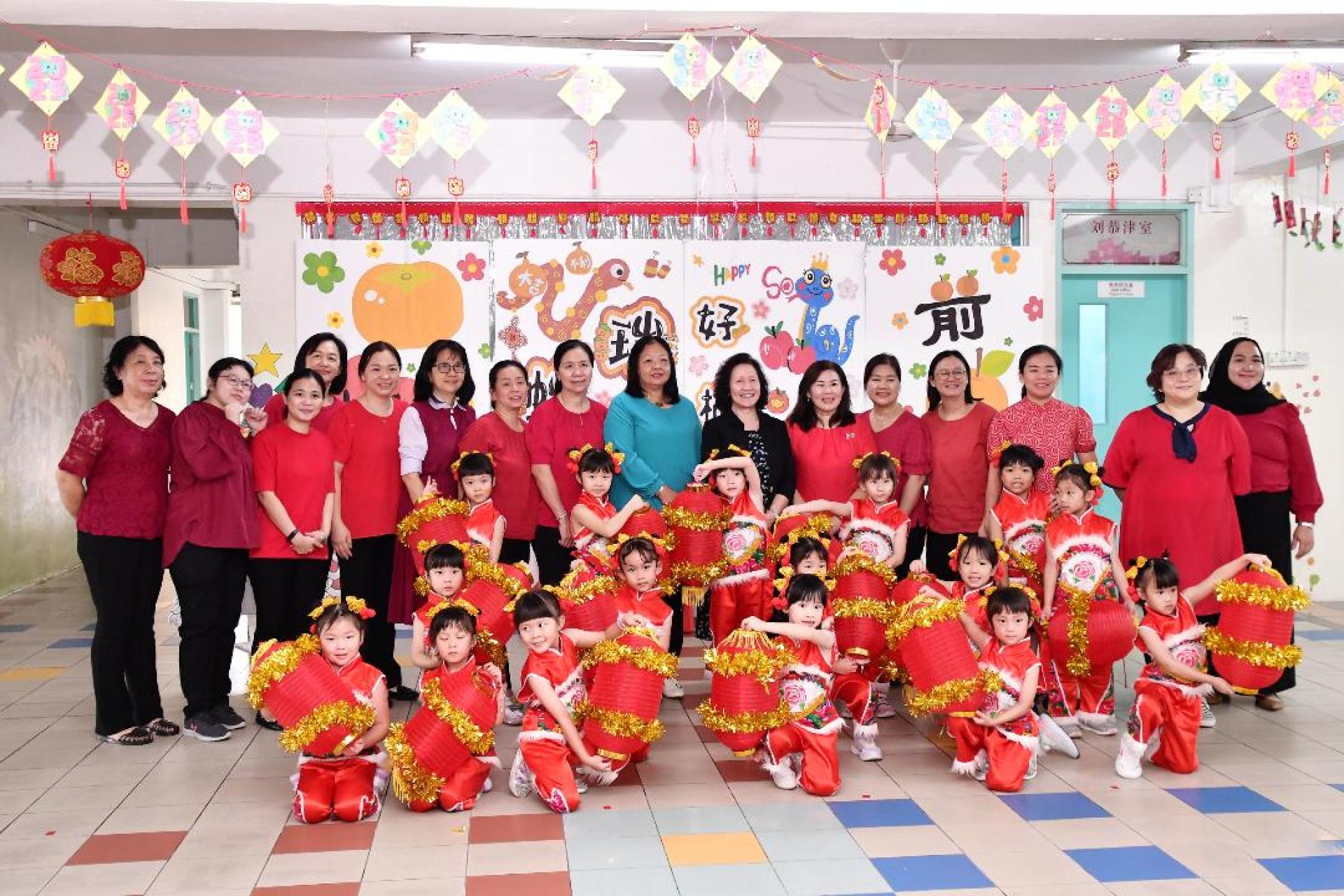 汶中幼儿园小朋友在庆祝活动中与许月兰校长（后排左十）、陈美典助理校长（后排左九）、沈曼玲助理校长（后排右六）及幼教们合影。