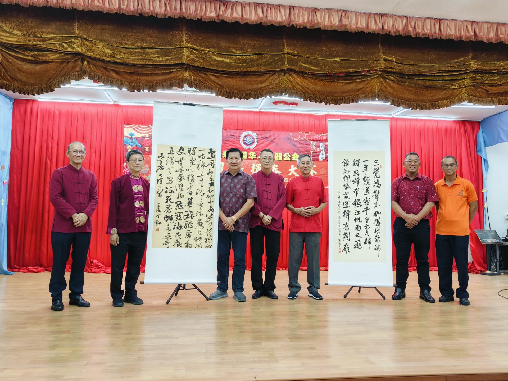 文协会长杨镇声（中）、华机会长陈观成（右三）、副会长刘芝新（左三），左起为文协副会长包平生、筹委会主席沈仁祥，右一起为文协副会长张永发、文协副会长许信等在赠送墨宝时留影。