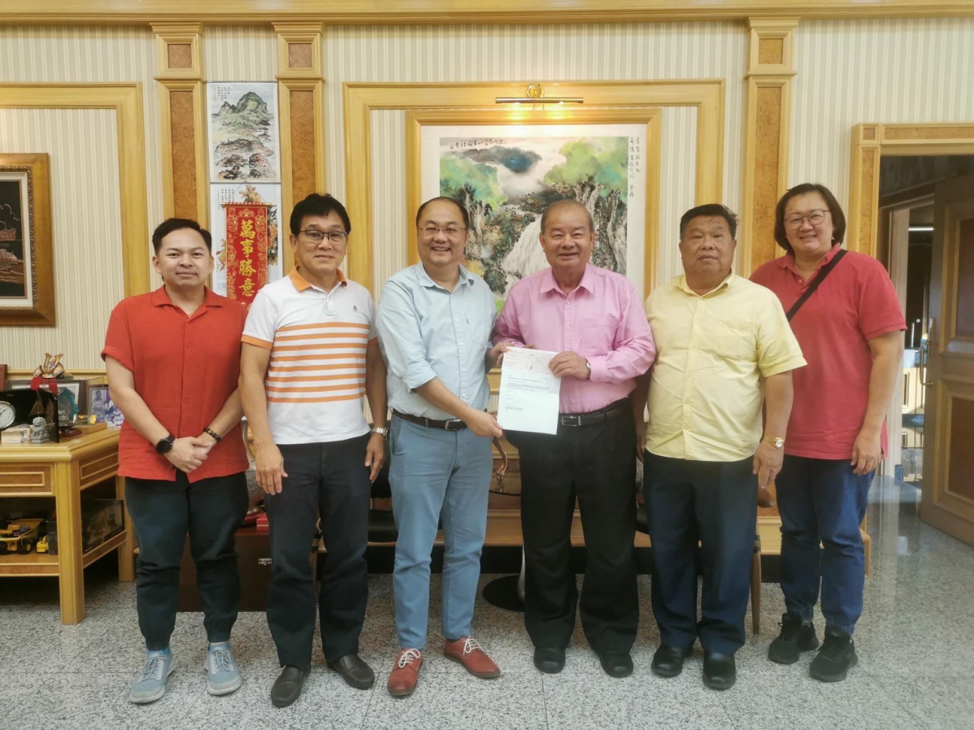 華總會長拿督吴健平（左3）移交邀请函予名誉顾问丹斯里拿督林昌和（右3）。