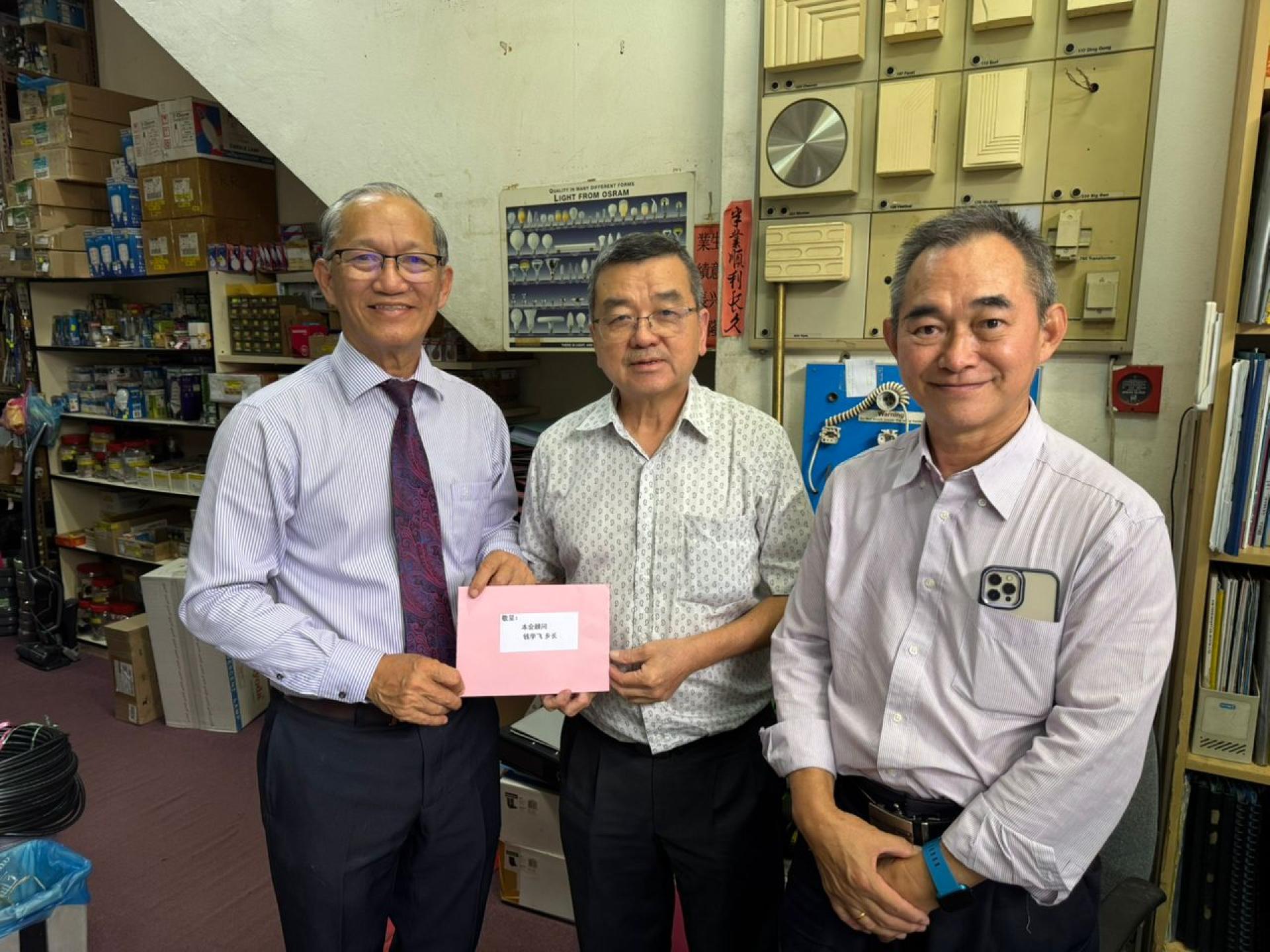 副会长包平生派送邀请函予顾问钱学飞。