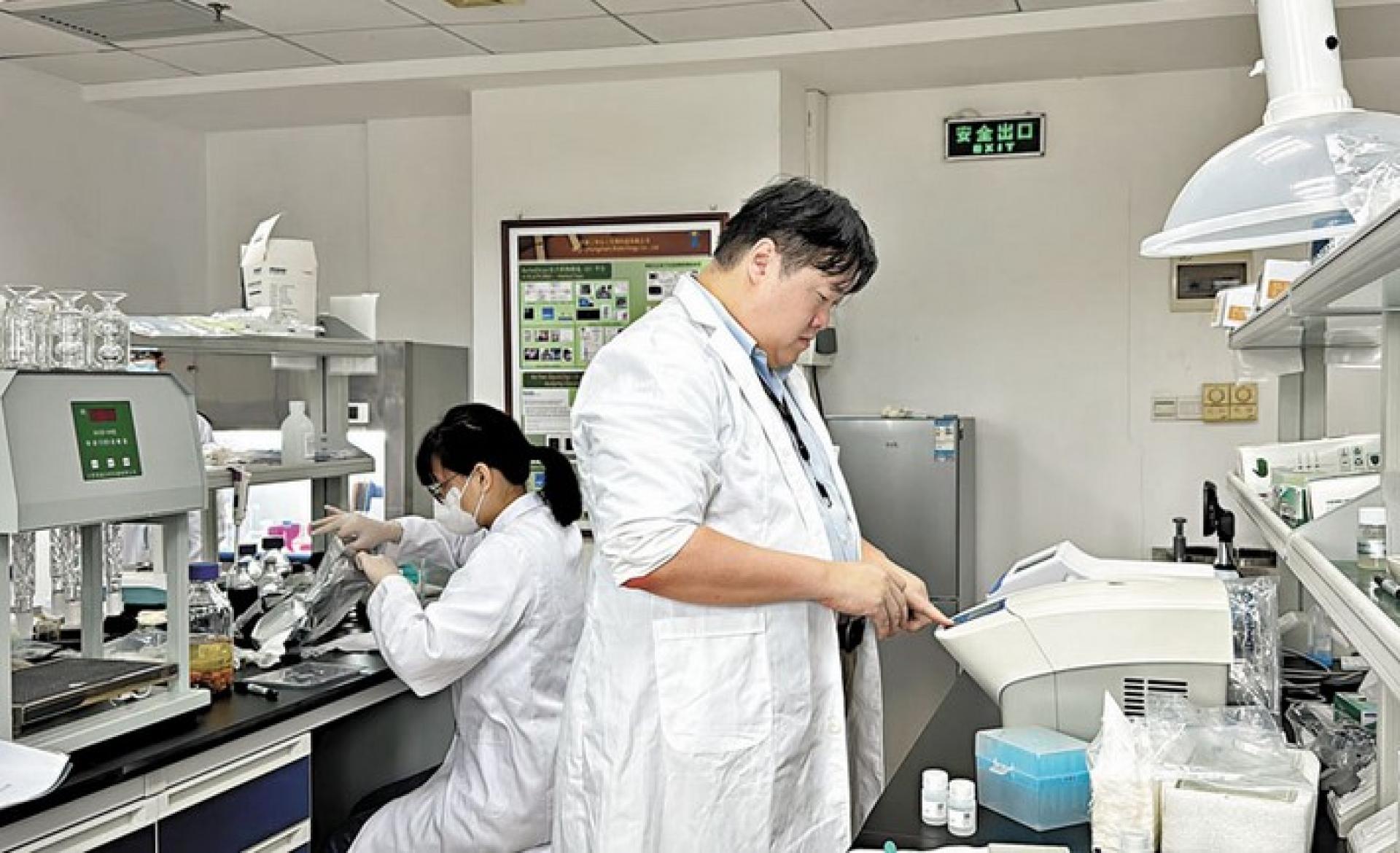 研工作者構成了廣東科技創新的重要支撐力量。圖為香港青年創業者和同事在中山的實驗室做實驗。 資料圖片