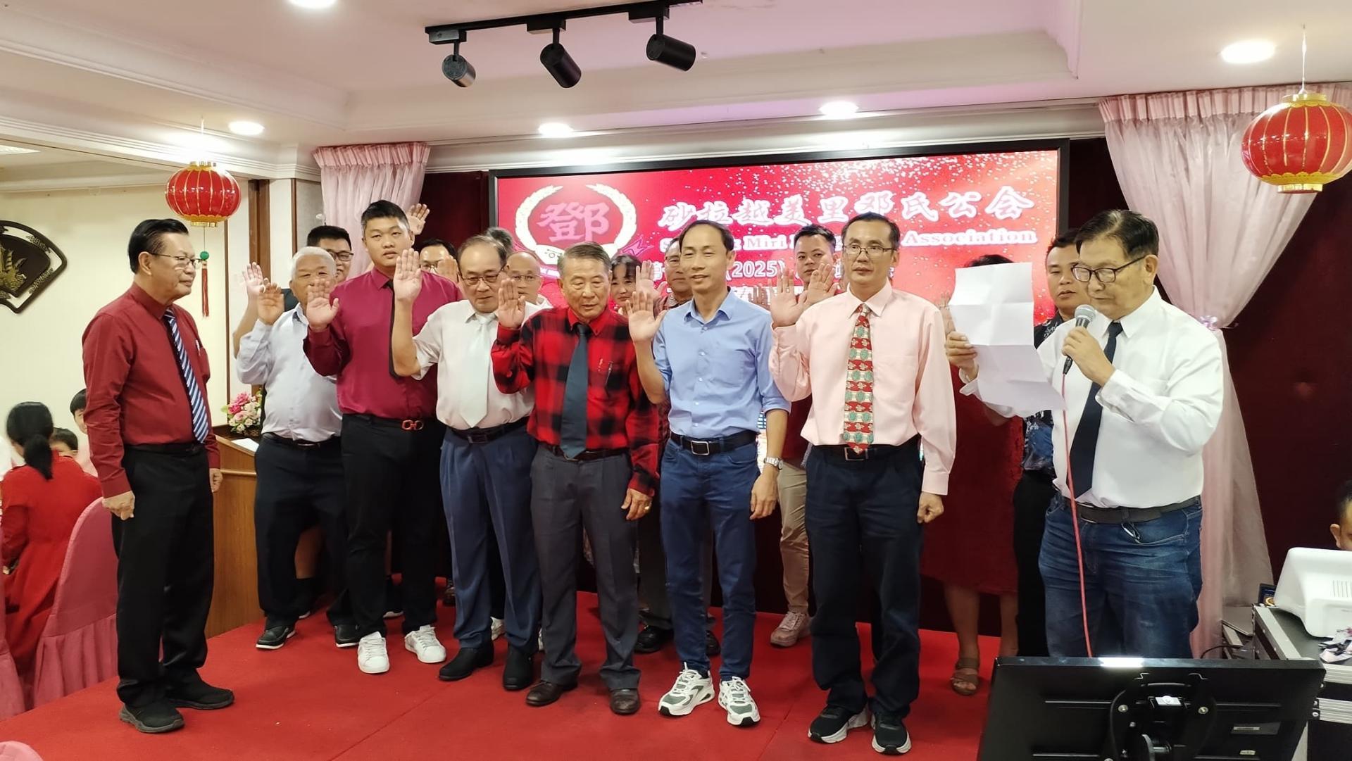 砂交通部长拿督斯里李景胜（左）监督美里邓氏公会新届理事新宣誓就职。
