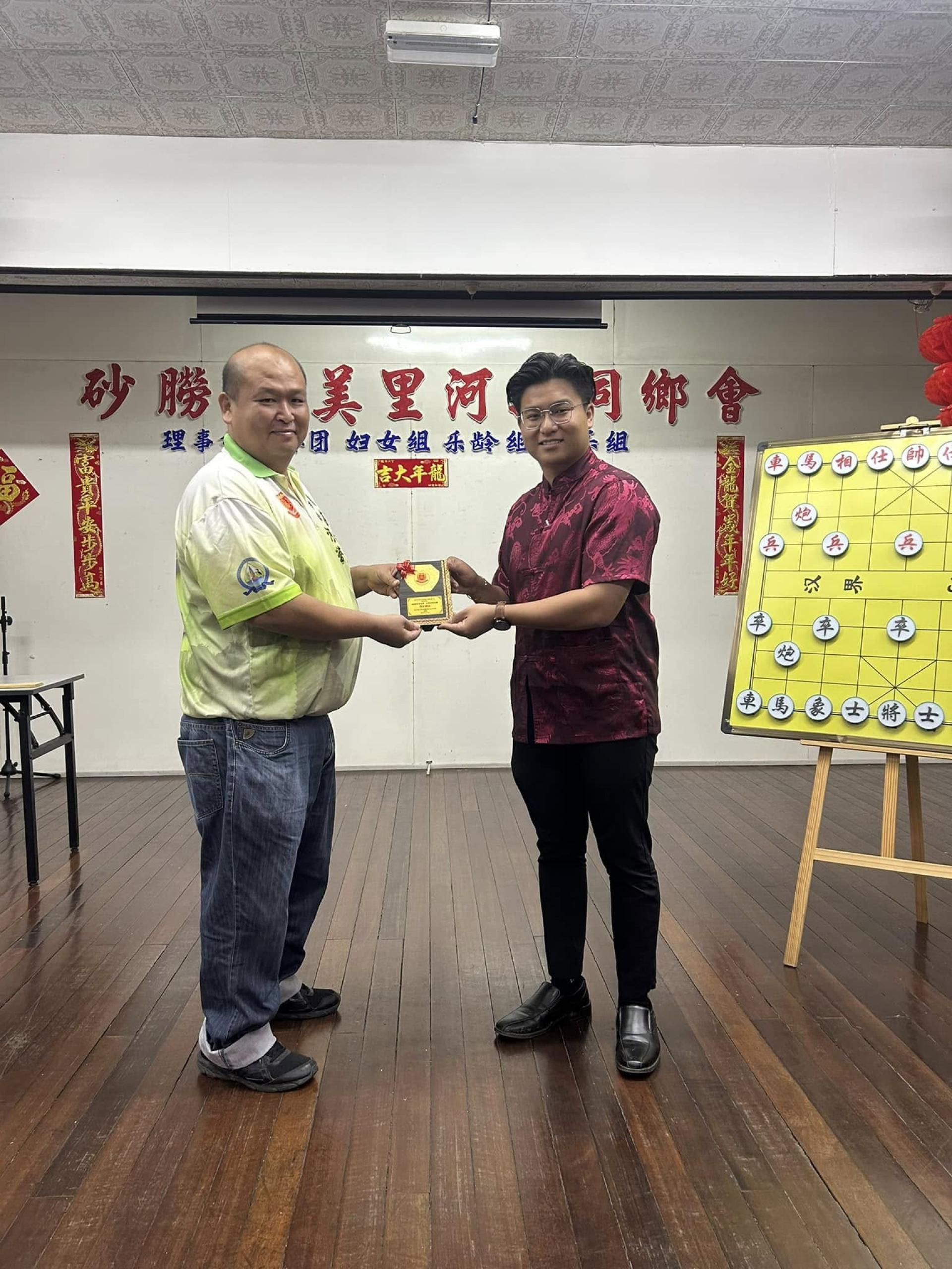 砂拉越美里河婆同乡会青年团团长张鸿庆（左）赠送纪念品于美里国会议员赵俊文代表邹梓建。
