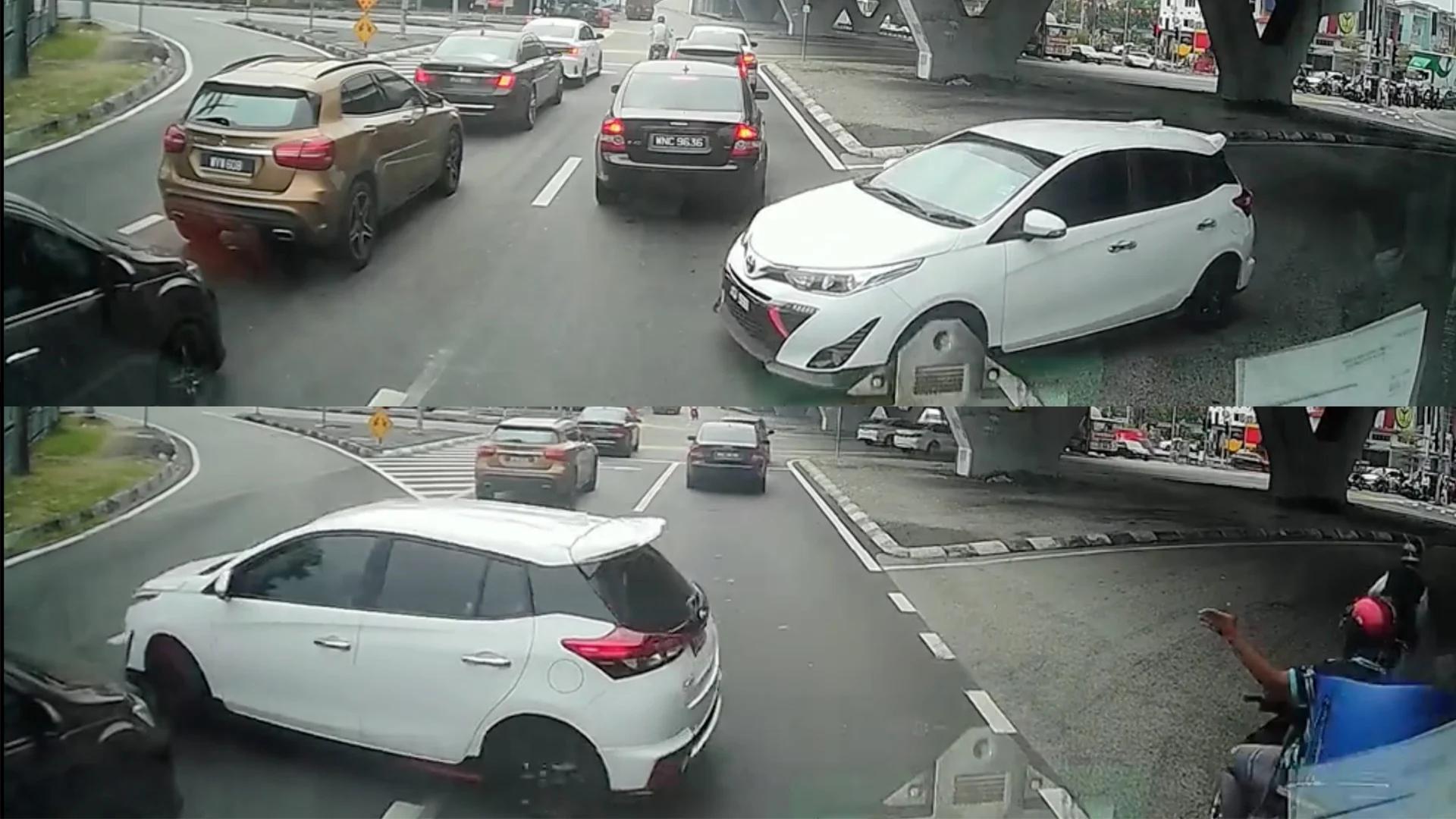 白色轿车反方向违规驶入U转道，还要一辆停在交通灯处等候的车退车让路。