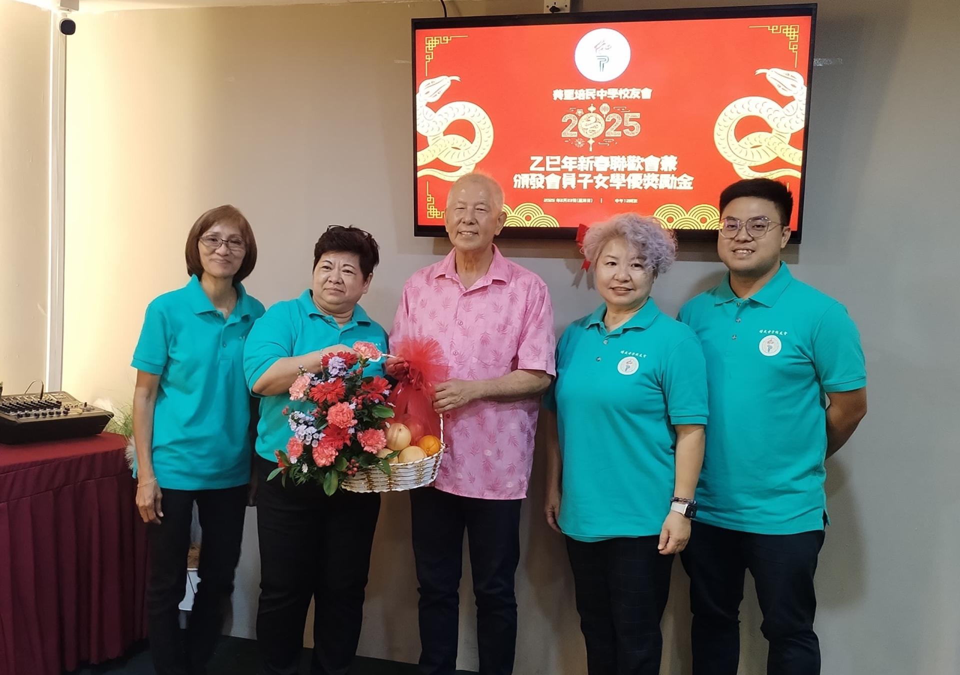 美里培民中学校友会主席黄金凤（左2）赠送纪念品给陈超耀。