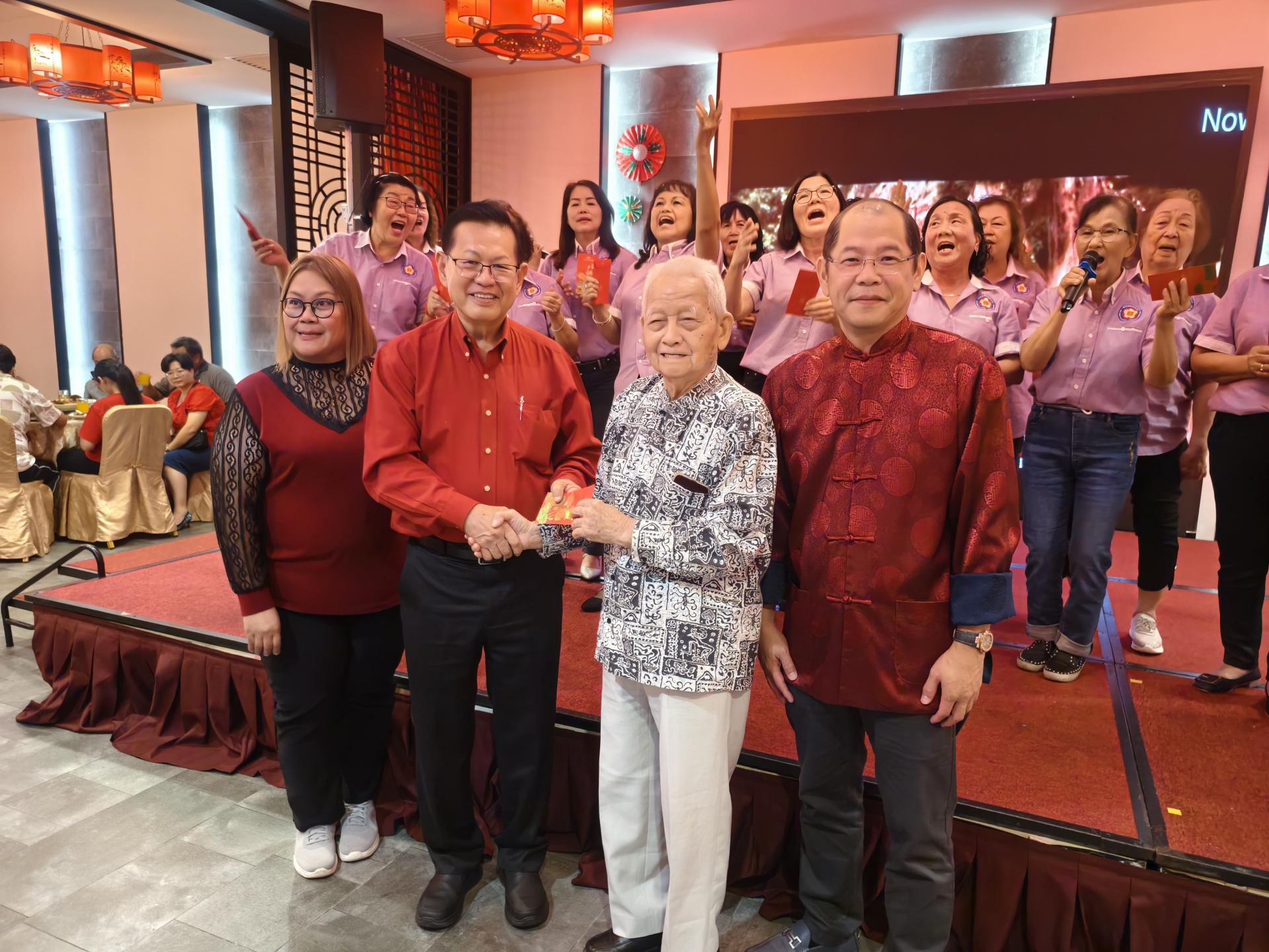 会长拿督斯里李景胜（左2）赠送乐龄红包给蔡高船。左为筹备会主席廖秀云，右为主席江先柱。