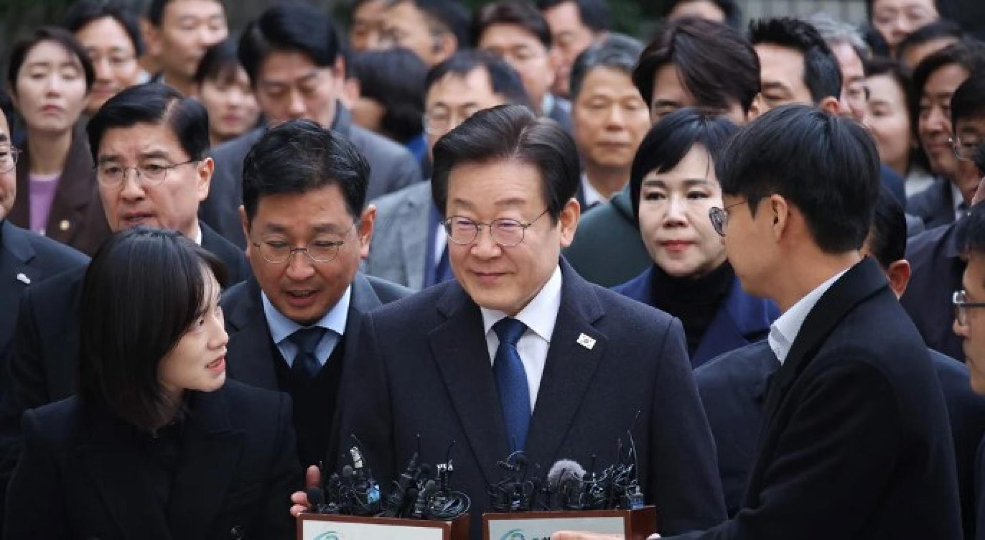 李在明（中）25日出庭，面对审讯结果。