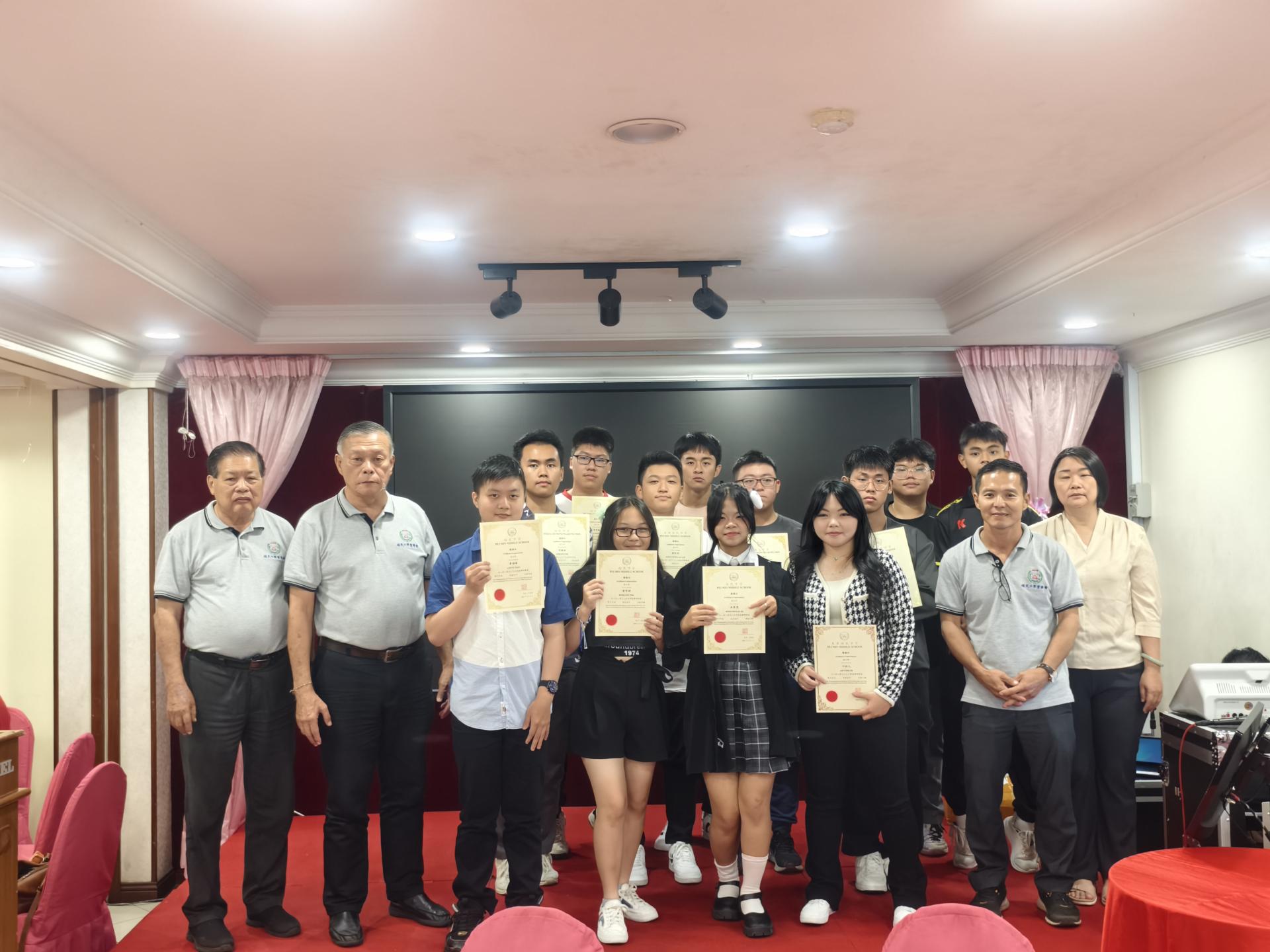 美里培民中学董事长许为隆（左2）颁发感谢证书给初一至十参与新春舞狮筹款活动的学生。