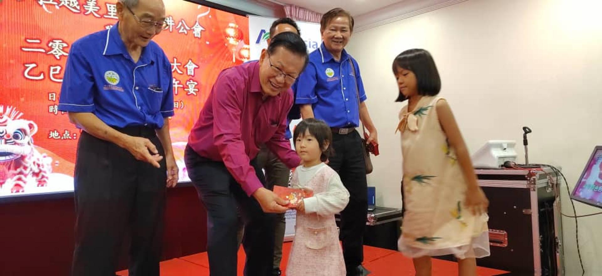 拿督斯里李景胜在美里农耕公会新春联欢午宴颁发红包予  会员子女。