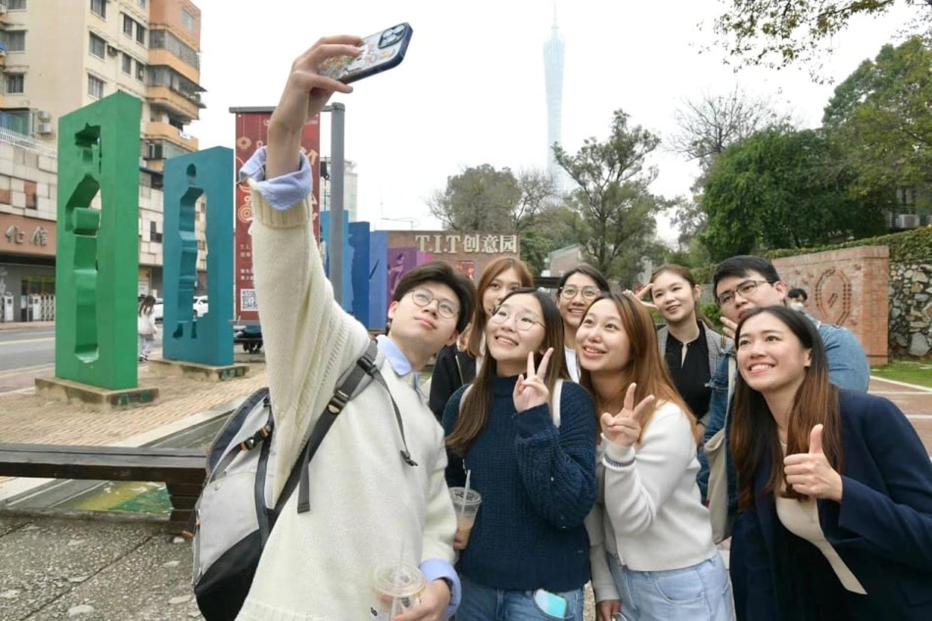 越来越多的港澳青年前往大湾区旅游、学习、生活。图为粤港青年在广州T.I.T创意园打卡合影留念。（档案照）