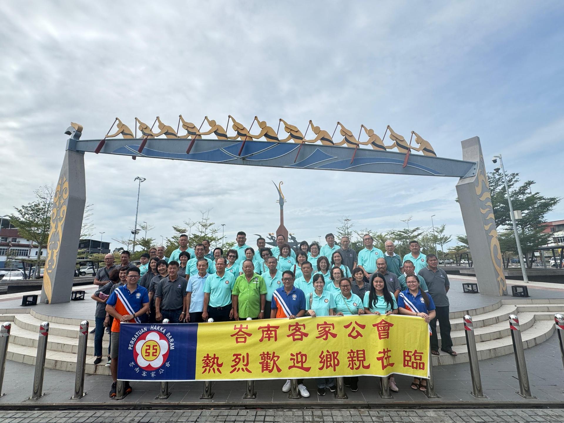 峇南客家公会理事、青年团团委及妇女组组委们与美里  客家公会代表团在马鲁帝四方城龙舟地标拍照留念。