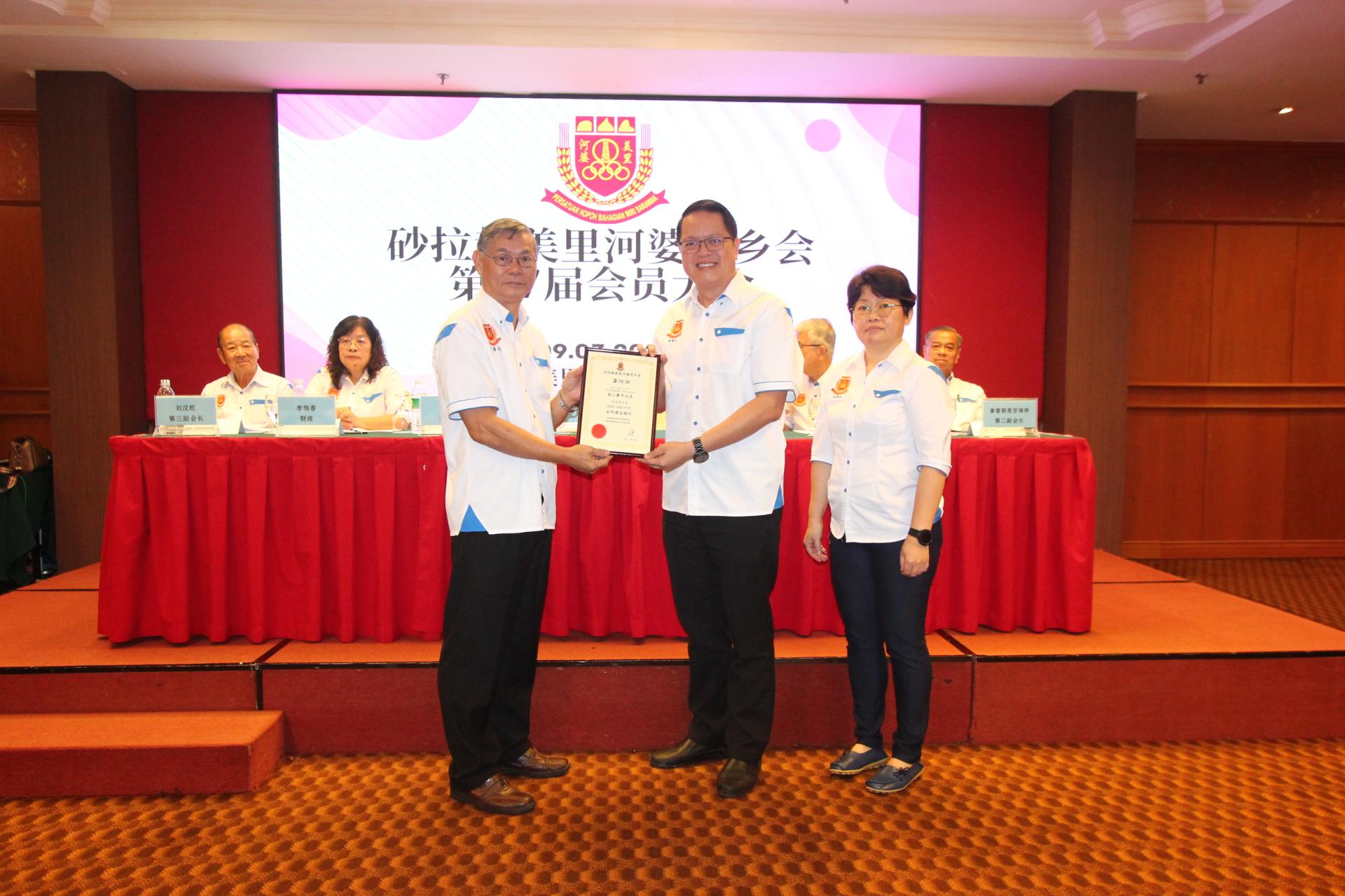 美里河婆同乡会会长蔡传创（左）颁发2025至2026年会所建设顾问委任状给美里市议员彭小菶。