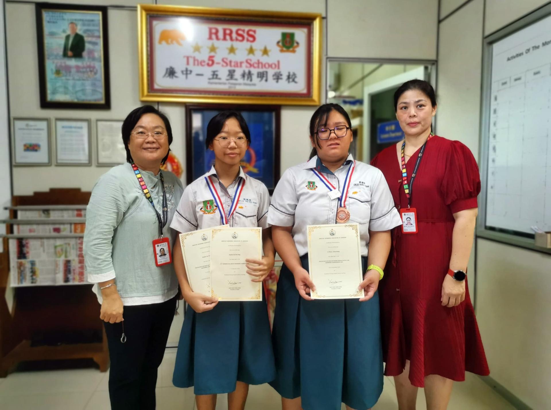 廉中游泳队负责老师陈立玲（左起）携学生陈佩芯及黄俪甜与校长江佩娟合影。