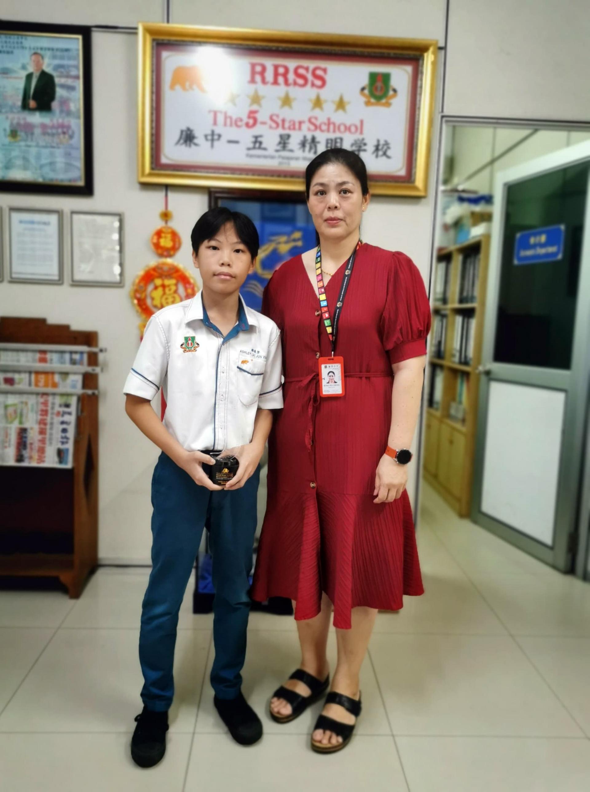 廉中生赖俊贤（左）与校长江佩娟（右）合影。