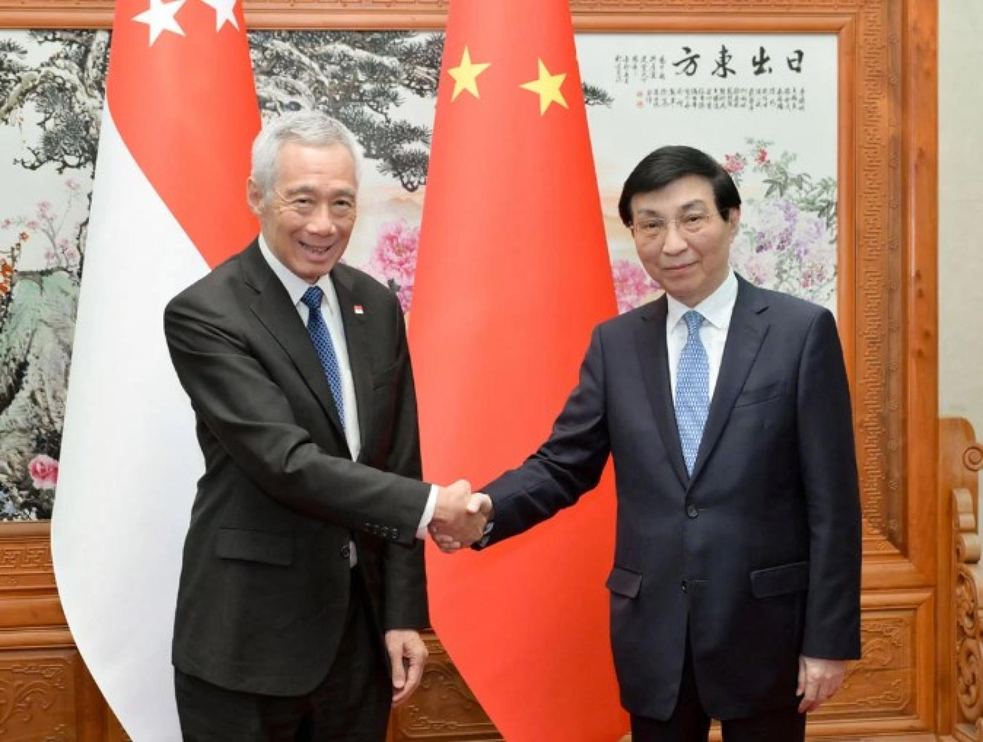 全国政协主席王沪宁（右）26日在北京会见新加坡国务资政李显龙（左）。