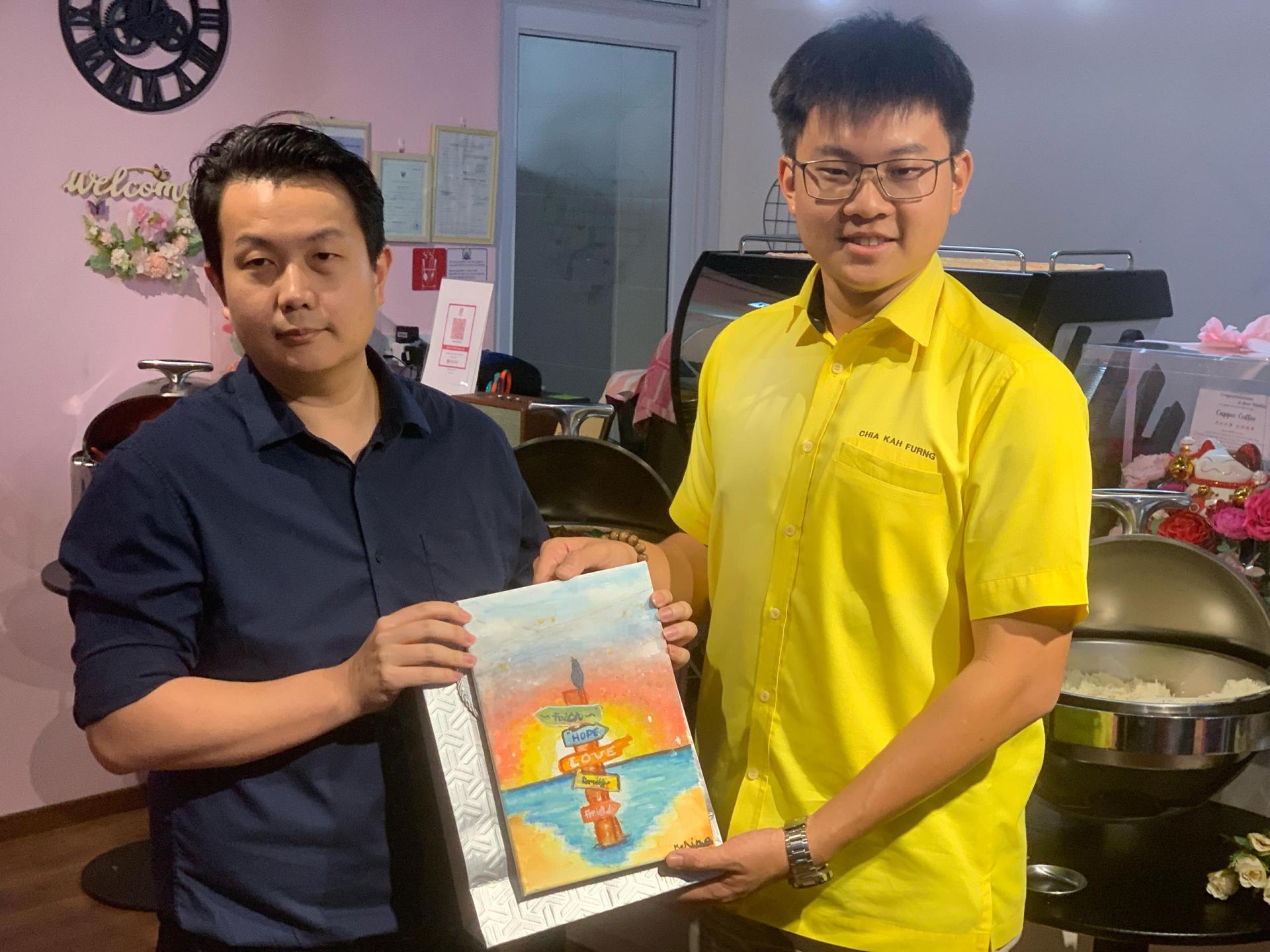 张训顺医生（左）赠送纪念品予拿督陈超耀机要秘书谢家洪时摄。