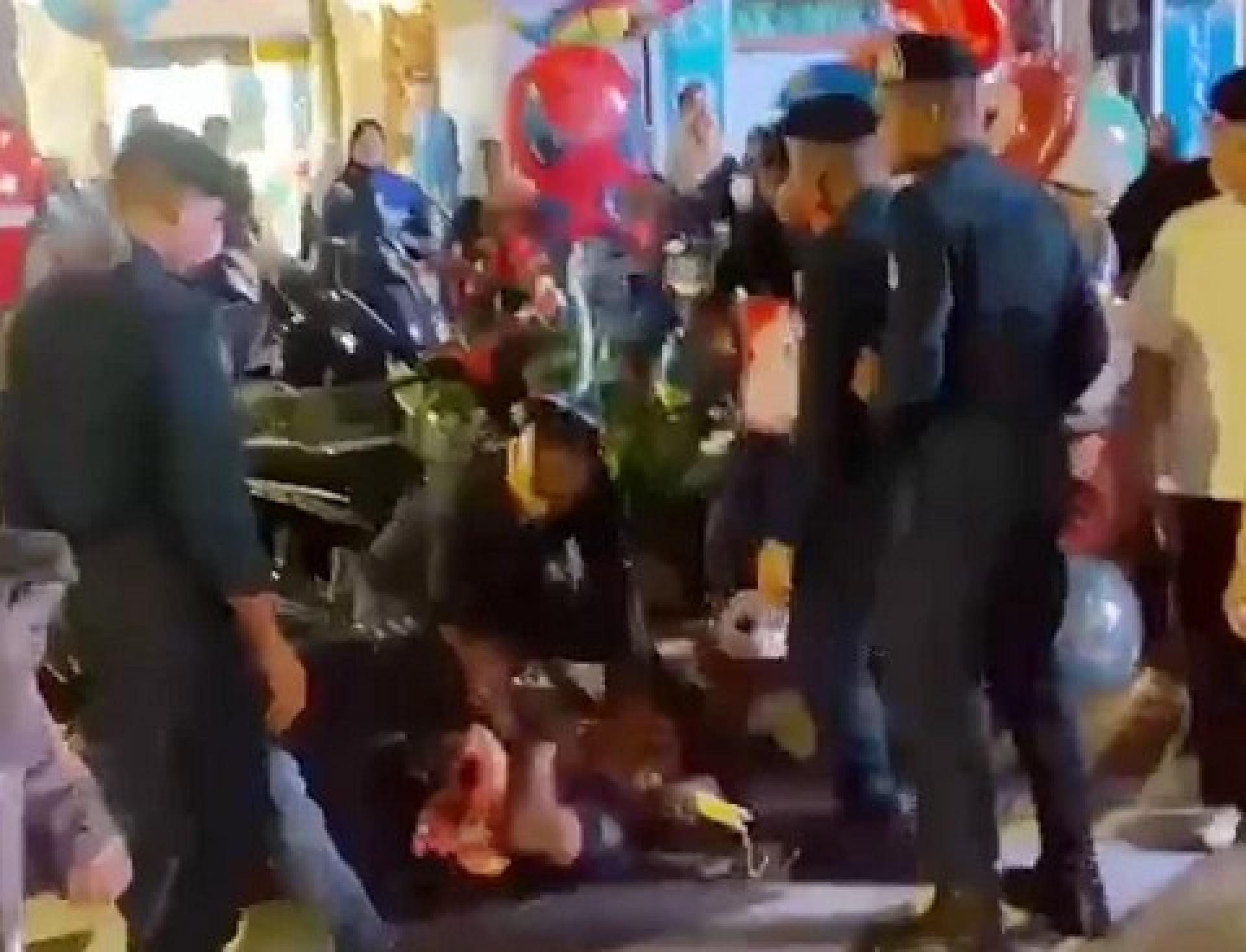 小贩被数名执法官员制伏。