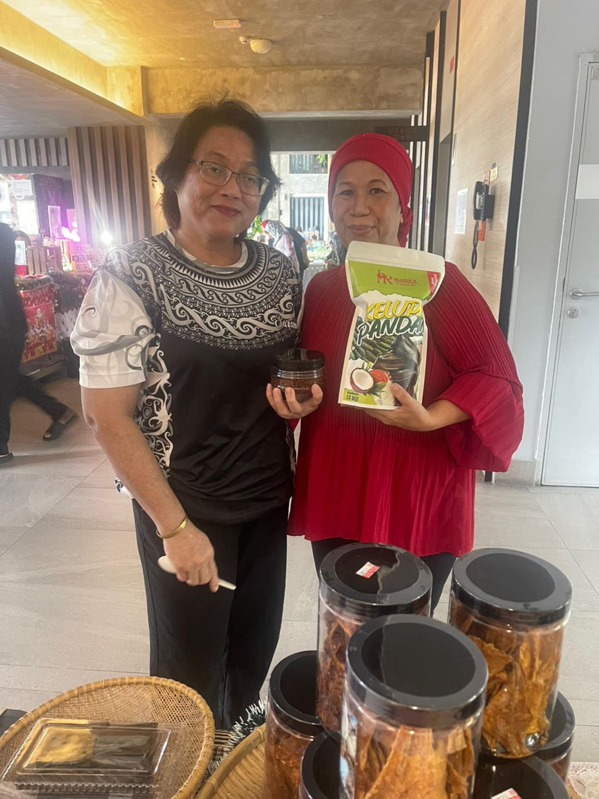Masnah Jamin（右）凭借传统美食马来粽制作生意支撑家庭生计，让这门传统手艺成为她的经 济来源。