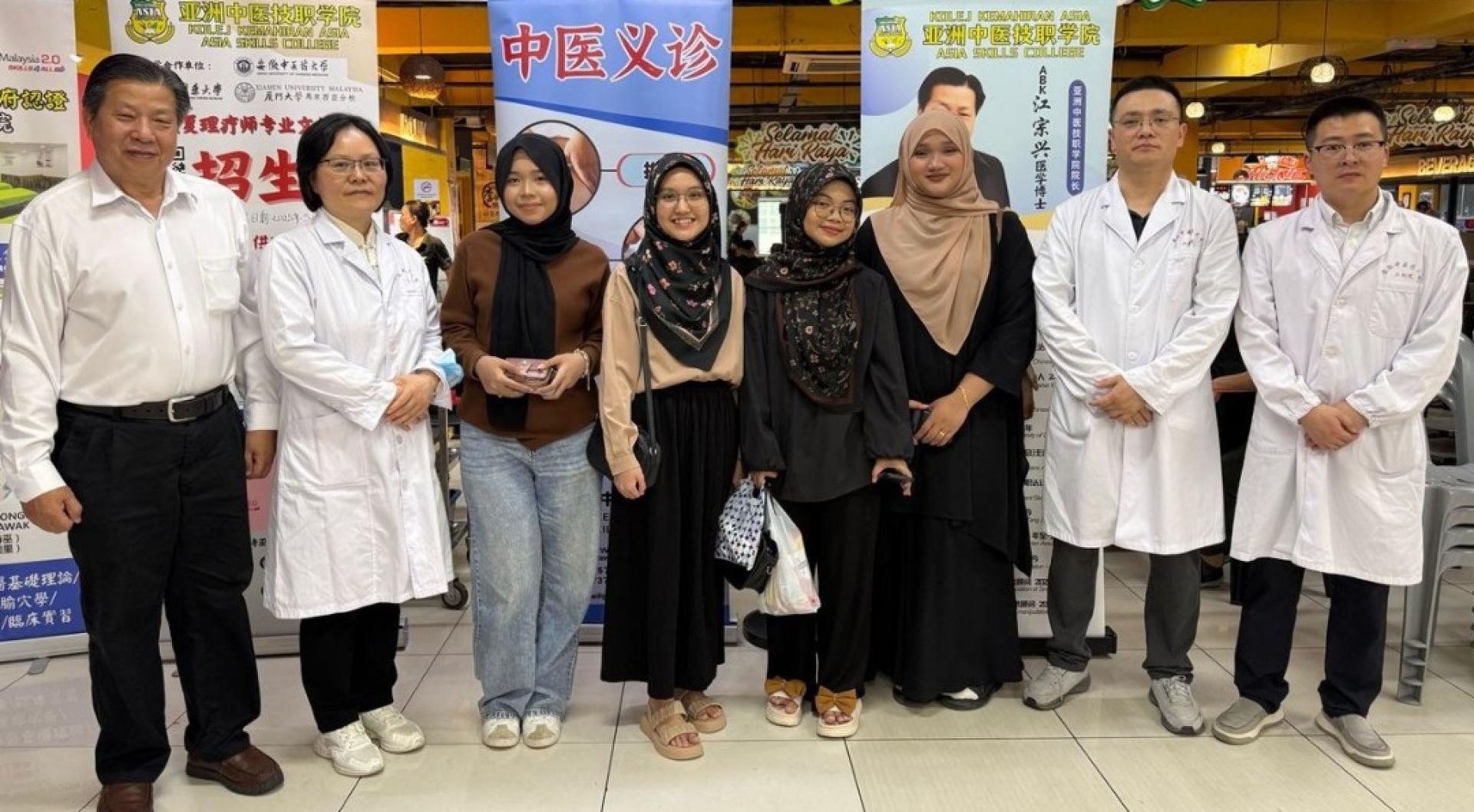江宗兴（左起）安排袁爱红医师在义诊时与马来同胞交流  。右起为曹应医师及吴勇医师。