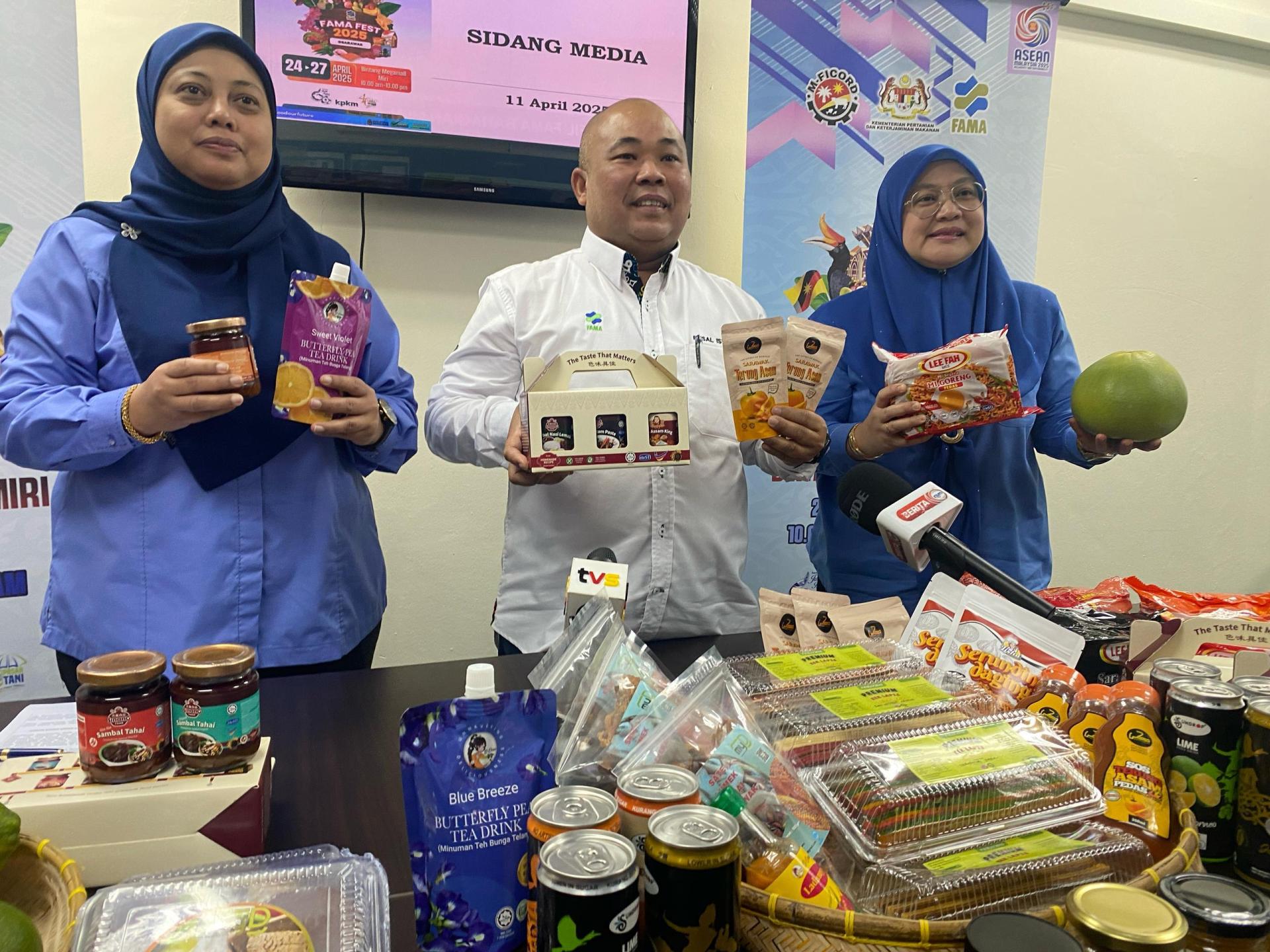 马来西亚联邦农业销售局农业食品发展单位副主任菲沙（中）农产品展销会新闻发布会上展示本地产品。