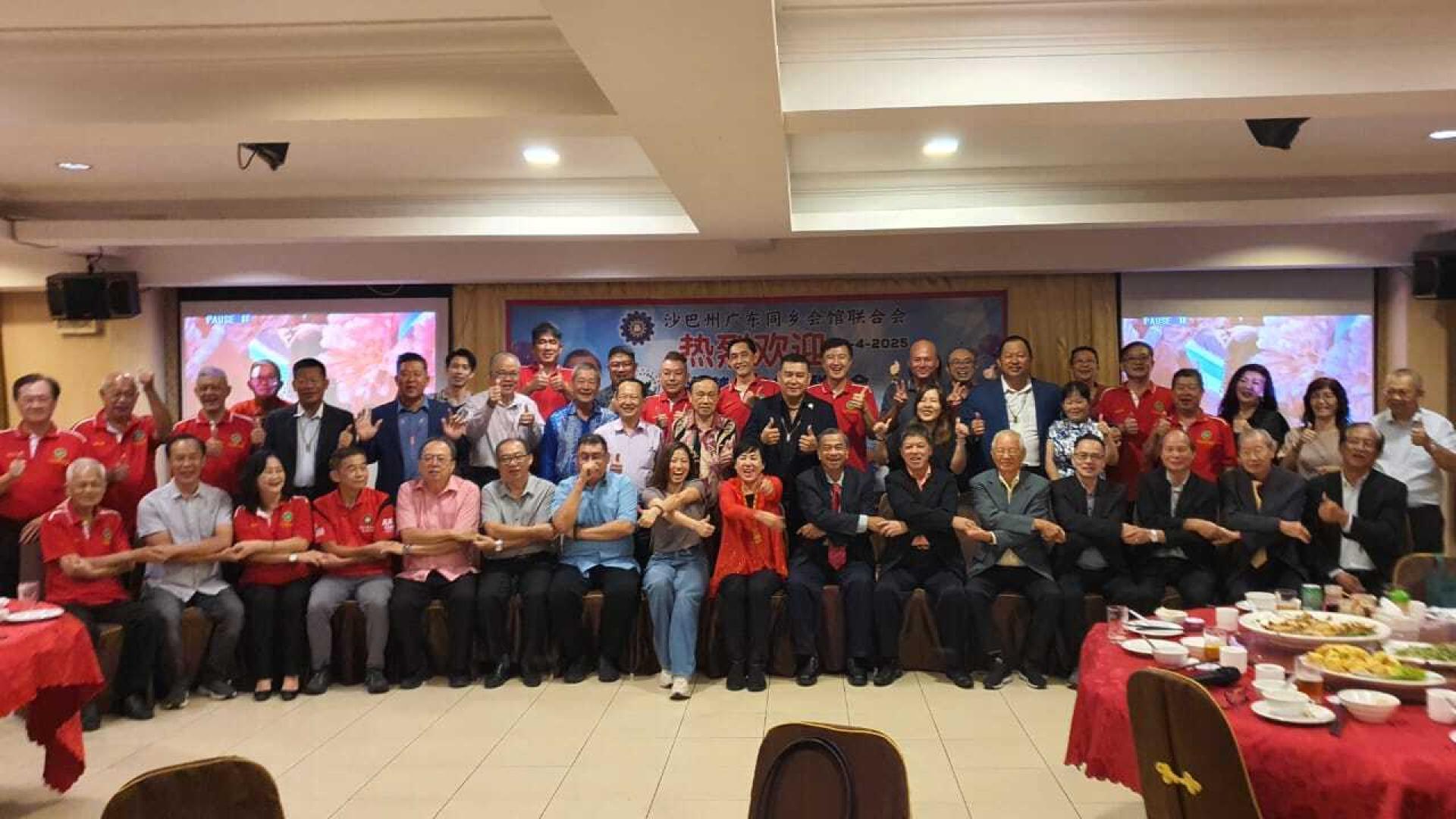 双方代表摄于交流晚宴上。前排左9 为沙巴广东会馆联合会会长拿督黄小娟，左10 为砂广东乡团联合会会长拿督斯里甘保祥。