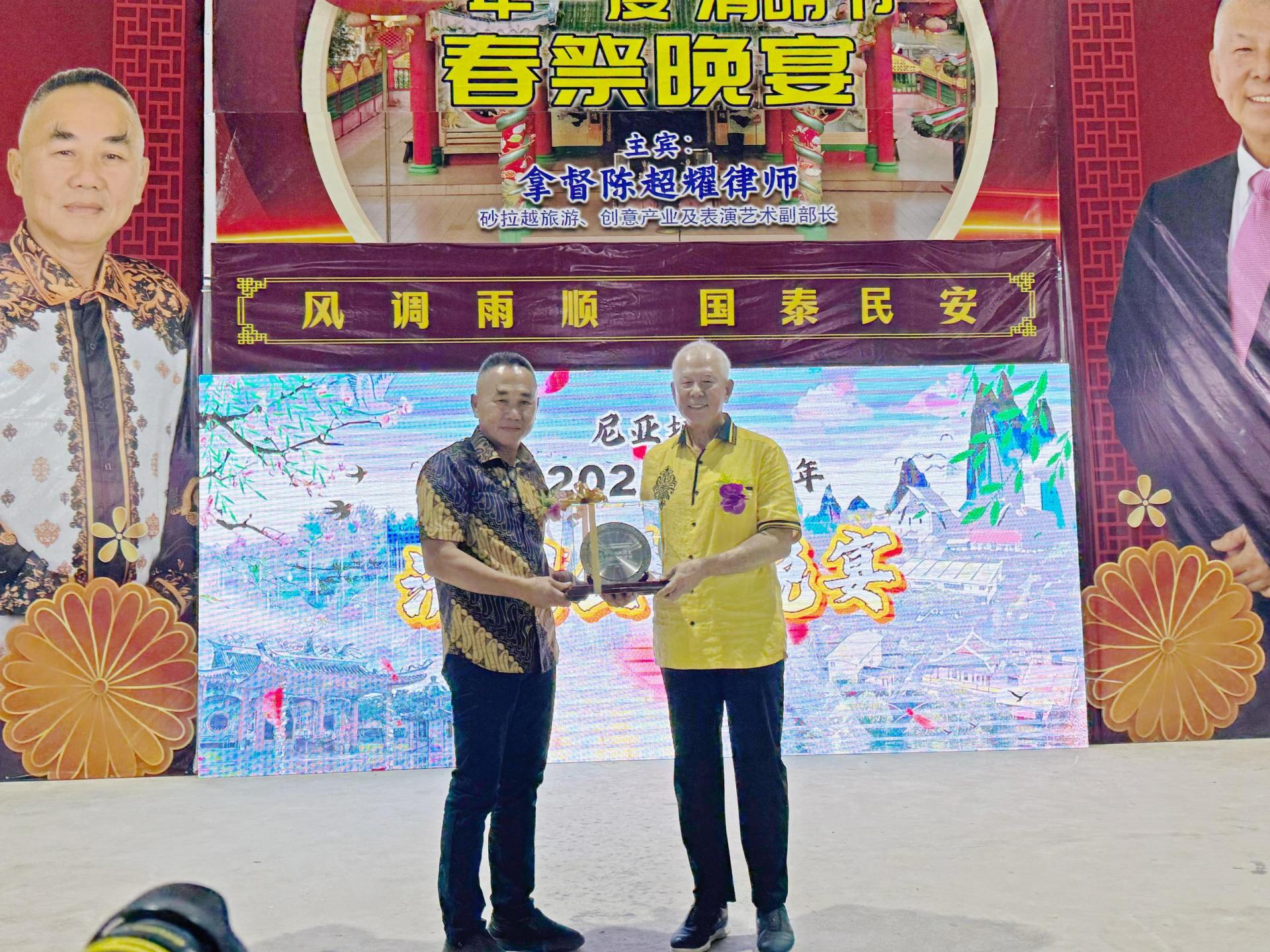 甲必丹何庆成（左）赠送纪念品予砂旅游部副部长拿督陈超耀。