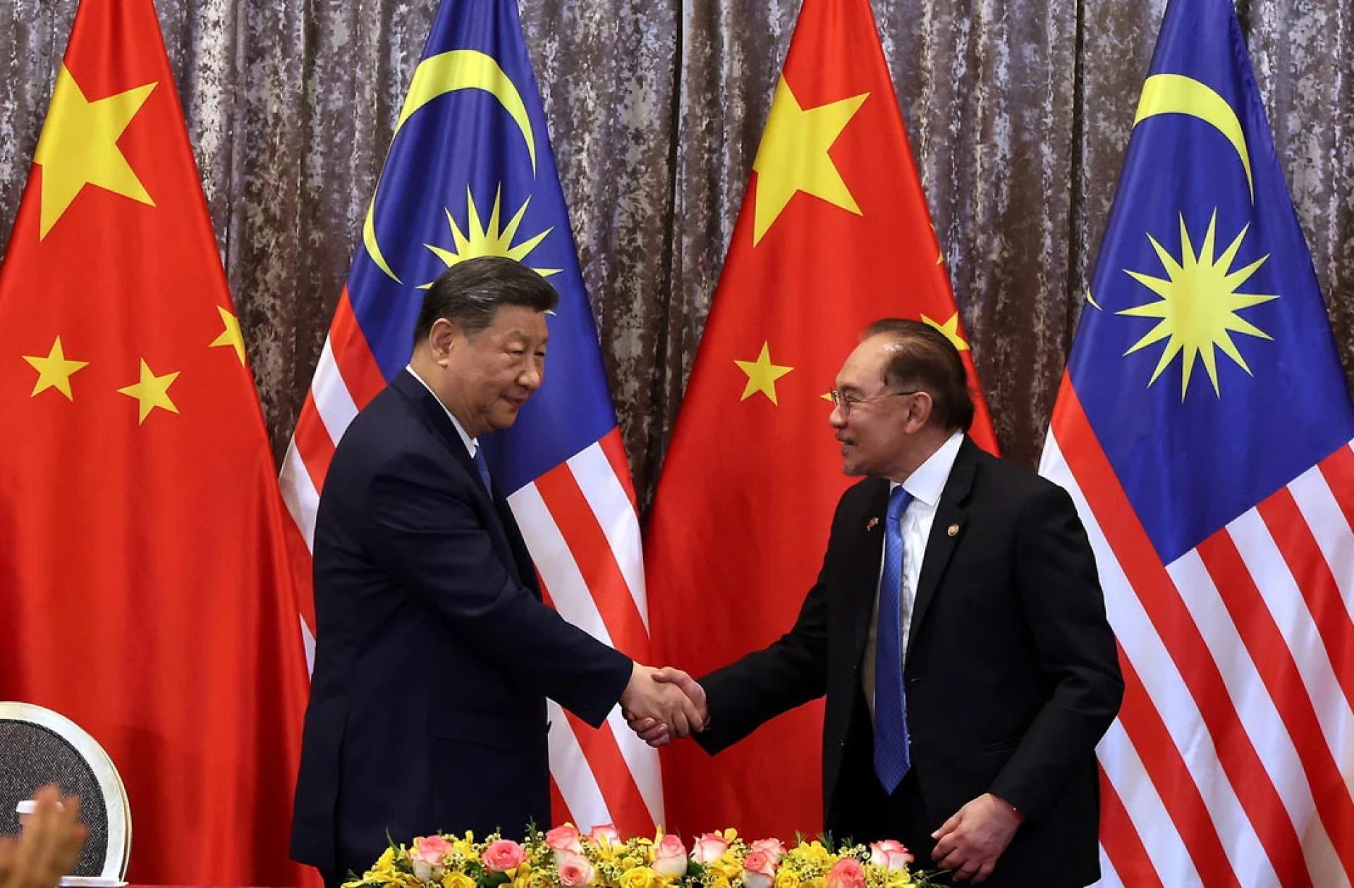 马中两国呼吁各方保持克制，避免采取使南海局势复杂化或紧张升级的举动。图为中国国家主席习近平（左起）与首相拿督斯里安华握手合影。