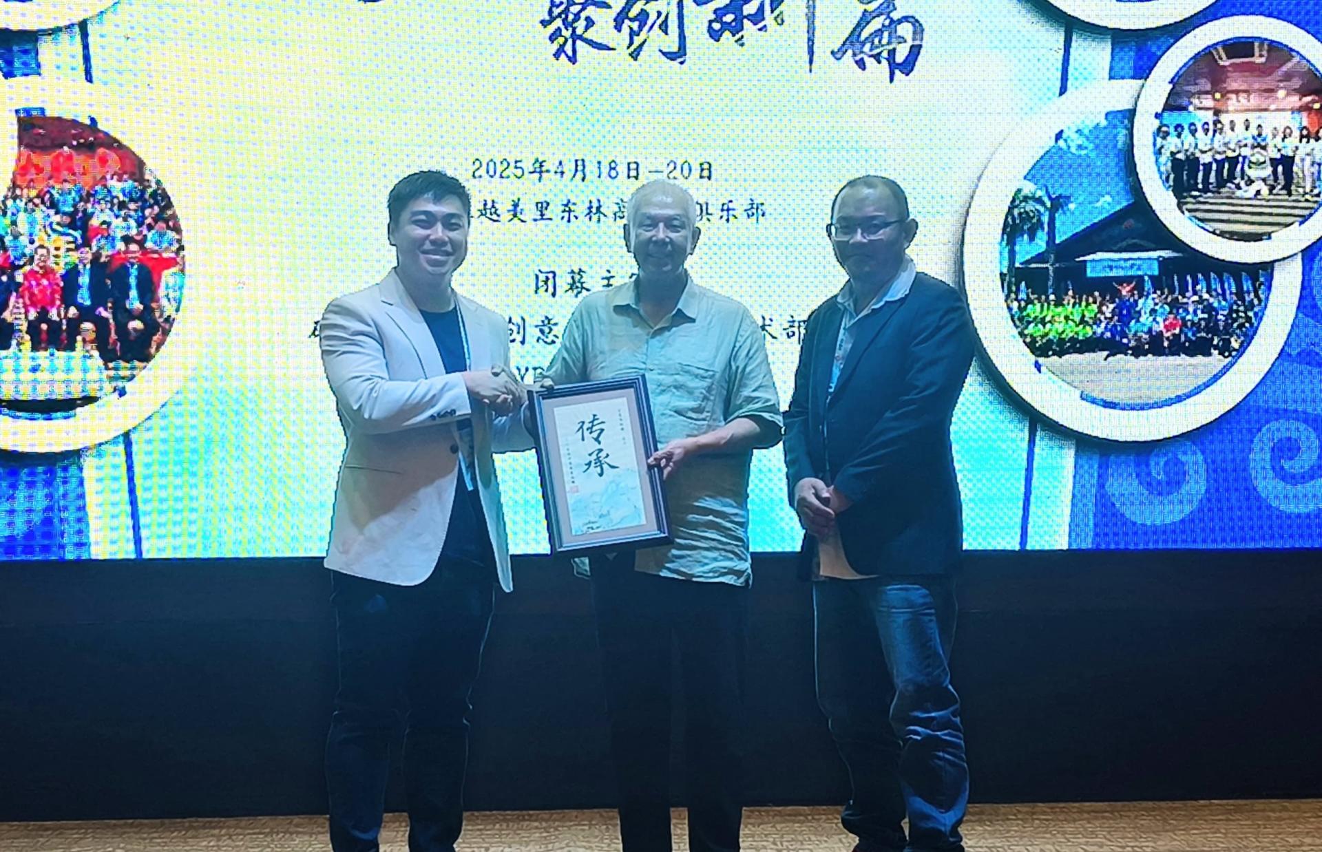 筹备会主席兼砂拉越客家公会联合总会青年团秘书赖矩桦（左）赠送纪念品予砂旅游部副部长拿督陈超耀。