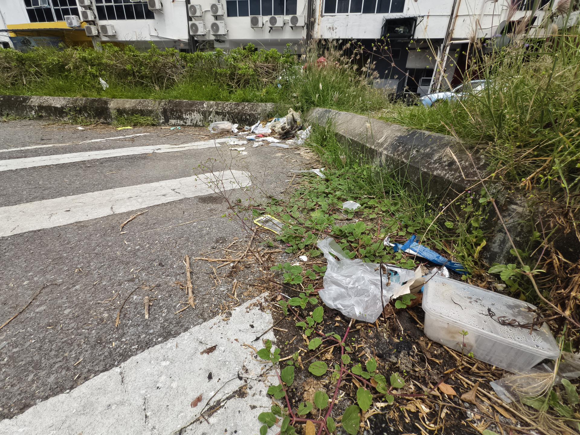 美里雅京商业中心附近泊车位旁，垃圾处处。