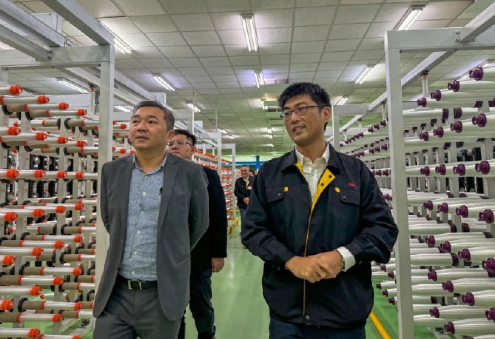 黄思汉（左）参观台玻集团生产线，了解企业入驻需求。
