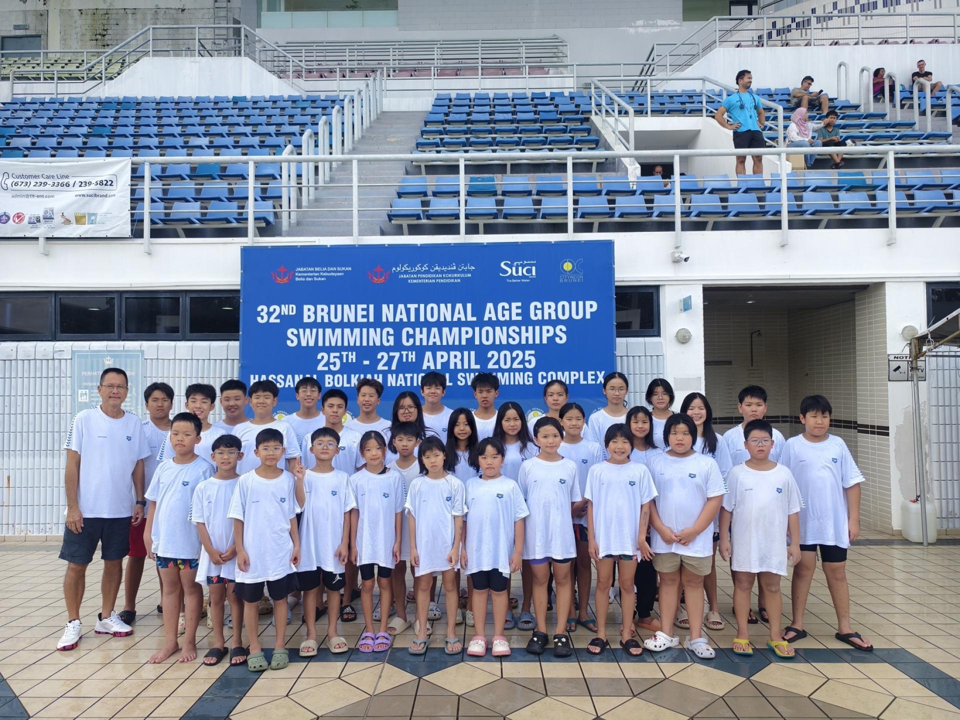 美里Top Speed Aquatic游泳俱乐部顾问兼教练钟易强（左1）在2025年第32届汶莱游泳锦标赛  结束后与部分游泳运动员合影留念。