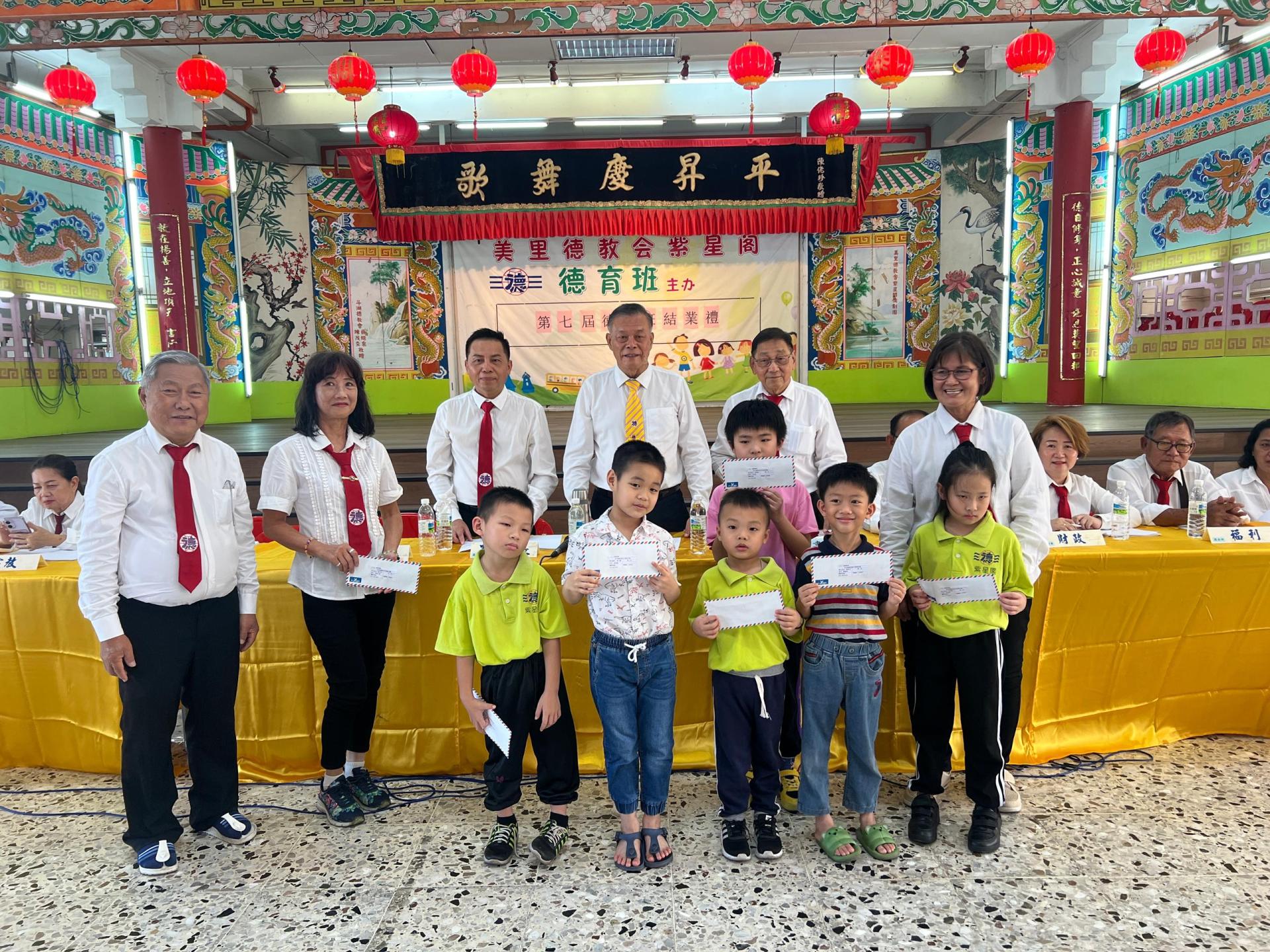 美里德教会紫星阁副阁长杨贤曾（左）颁发阁员子女学优奖励金予幼稚园组后合影。