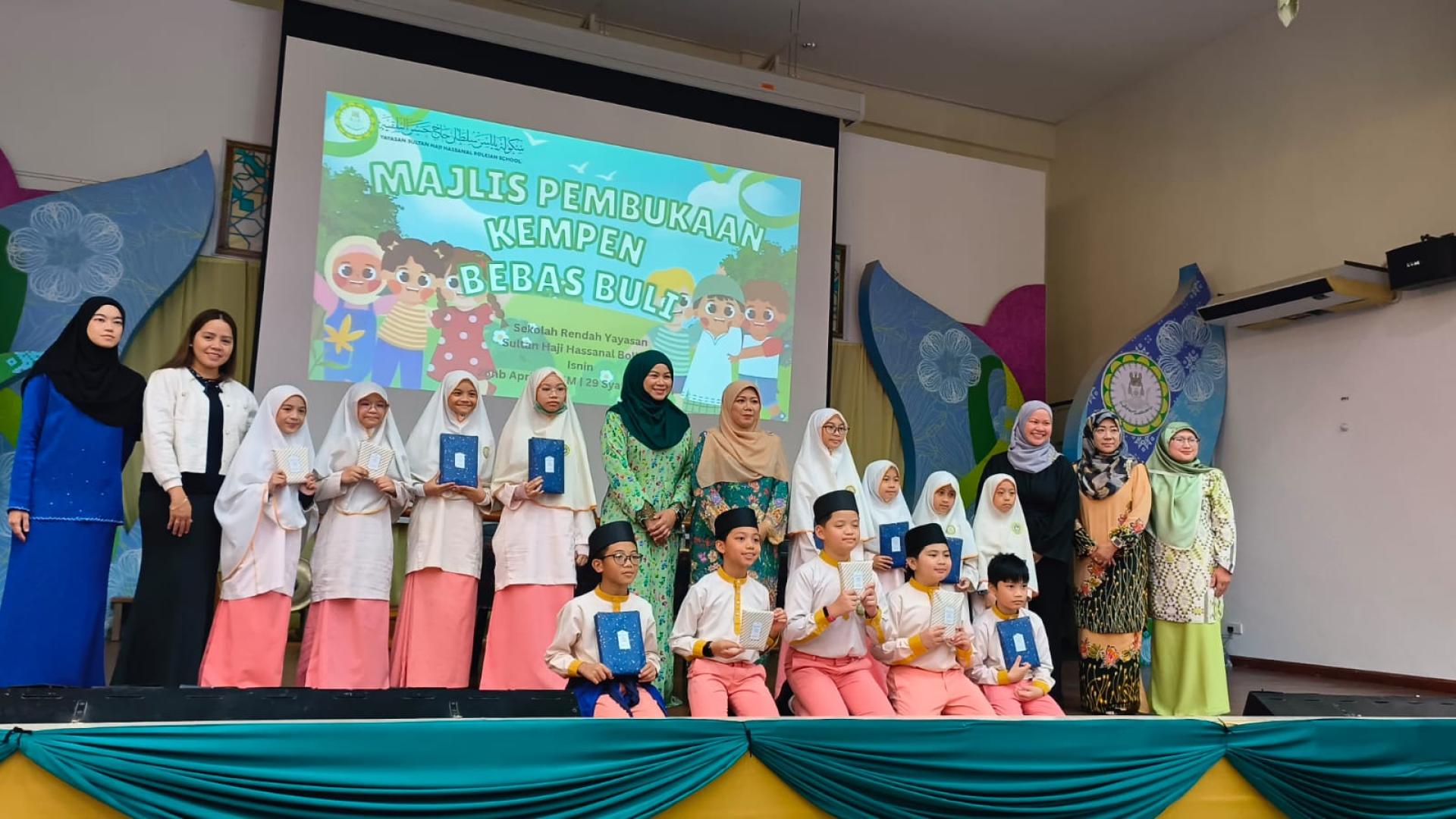 Winners of the “Anti-Bullying Poster Design Contest” and anti-bullying video competition pose for a group photo with the principal, teachers, and guests.