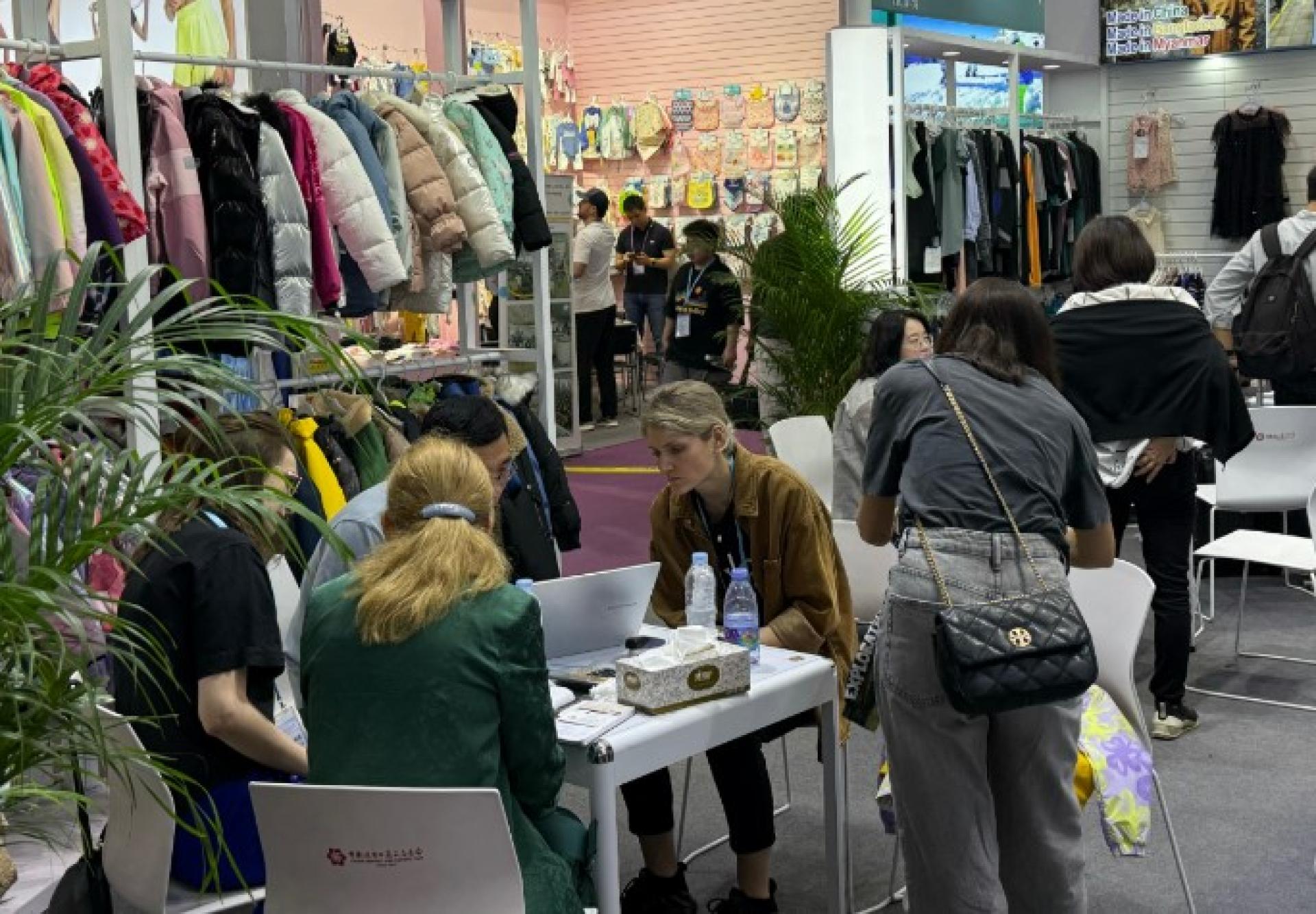 5月3日，广交会采购商在展位向中国参展商了解服装设计细节。