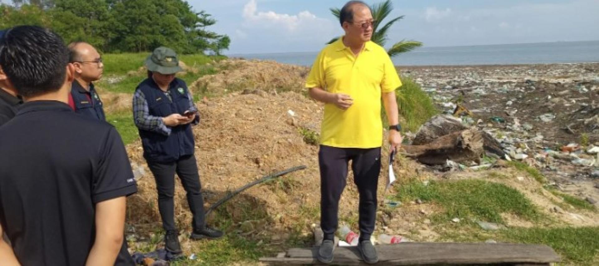 潘隆铭巡视丹绒峇都海滩污染情况。