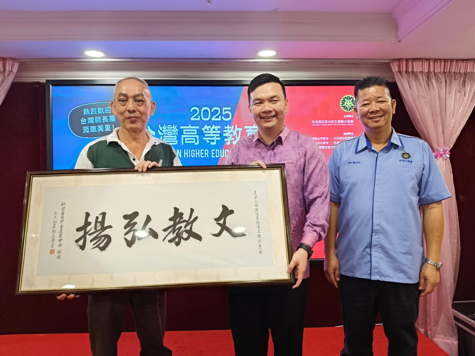 美里留台同学会主席林国台（左）赠送纪念品予美里区国会议员赵俊文，右为砂留台同学会总会  长萧特财。