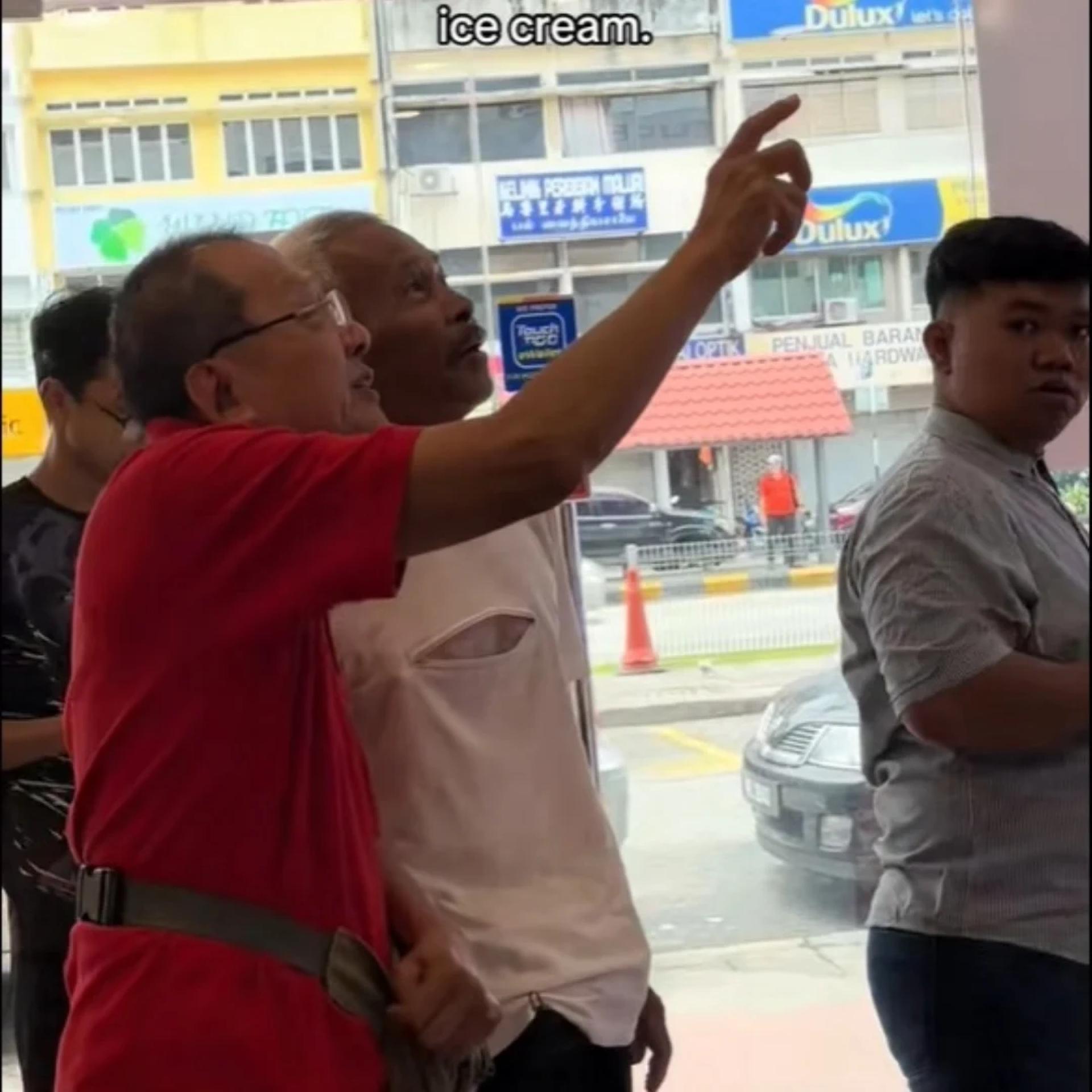 华裔老翁逐字教导巫裔老翁如何唱蜜雪冰城主题曲，以换取免费雪糕。