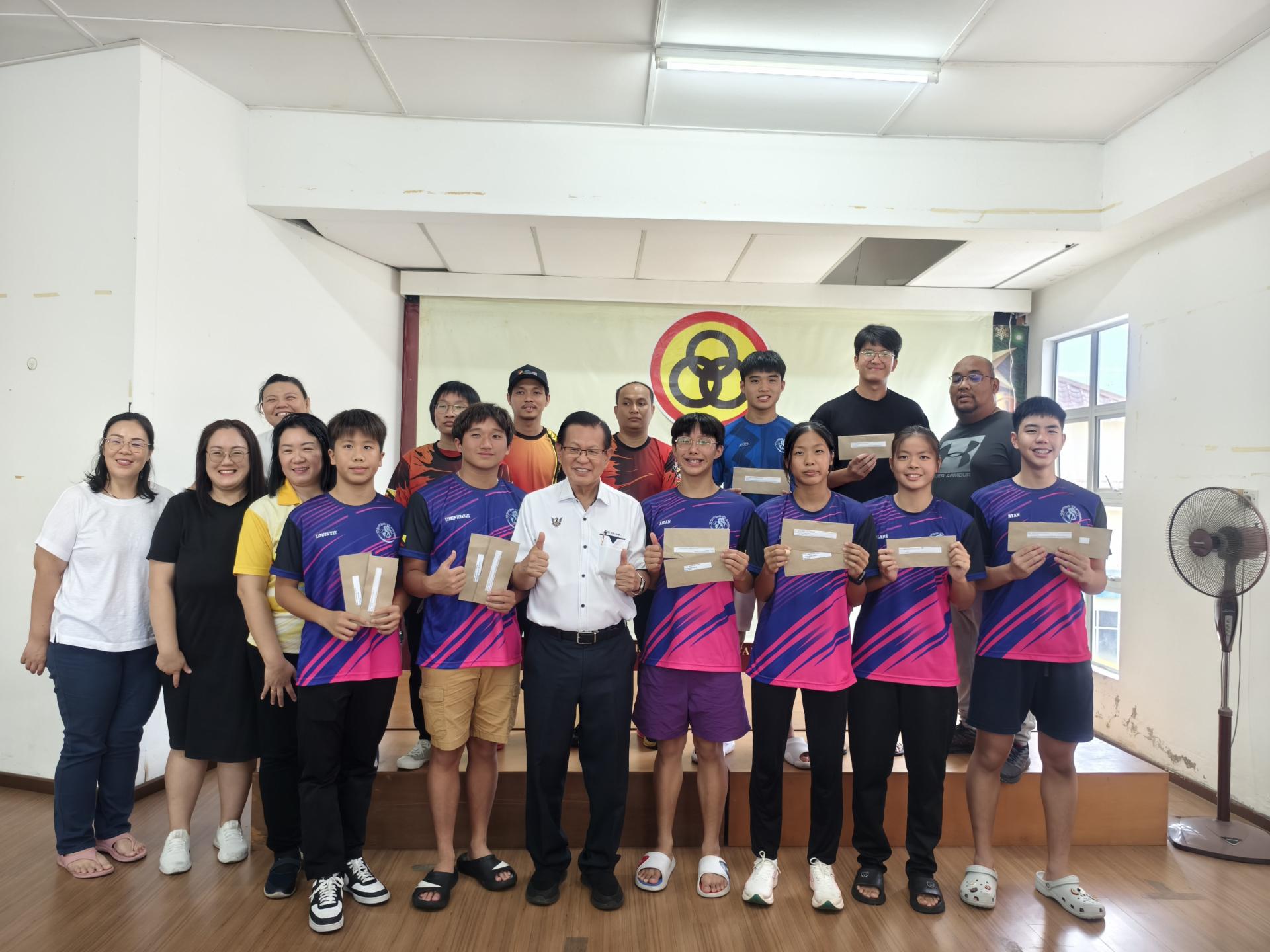 砂拉越交通部长拿督斯里李景胜（中）在美里业余游泳协会署理主席陳志熙（后排右1）、副主席陈柃鸰（左3）及理事们陪同下，颁发奖励金给代表参加砂拉越与海外比赛标准表现优异的游泳选手合影。