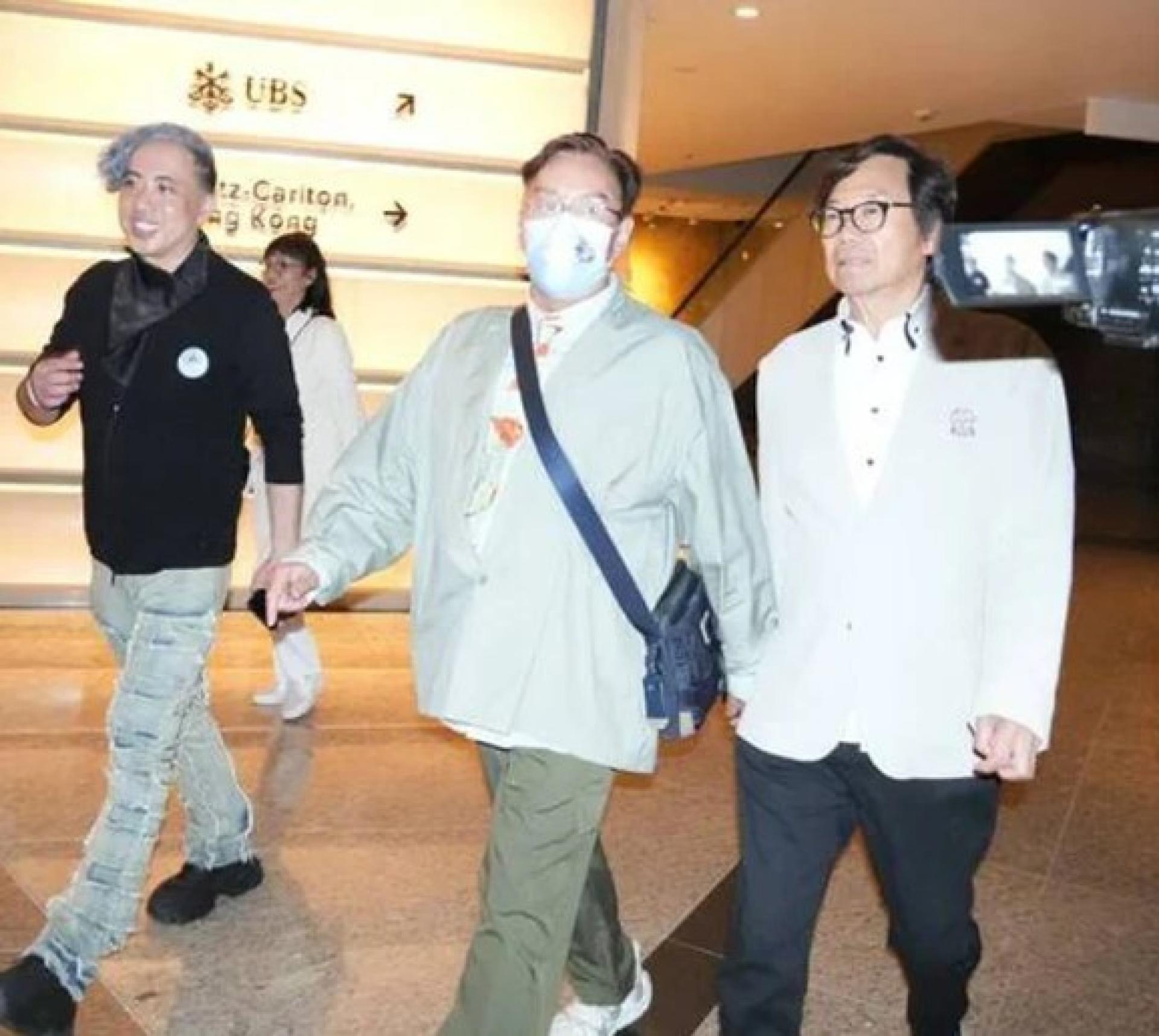谭咏麟（中）戴着口罩离开时，被问到有没有见到陈百祥？他说有。