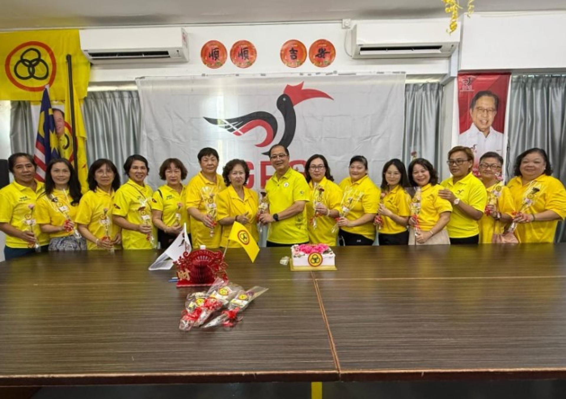 潘隆铭为人联民都鲁支部妇女组元老陈亚兰献上一朵康乃馨。