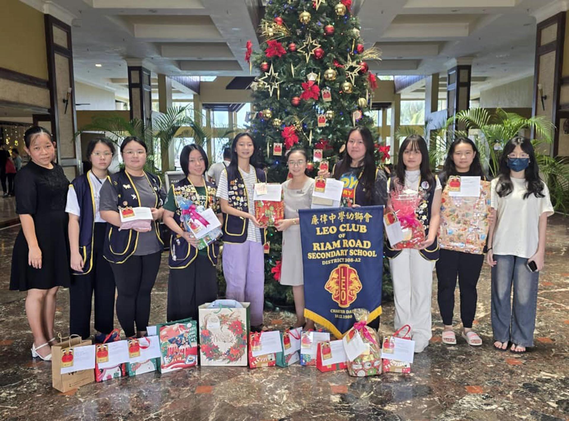 廉中幼狮会筹委会主席杨芊惠（左5）与团队移交圣诞礼物给酒店代表。