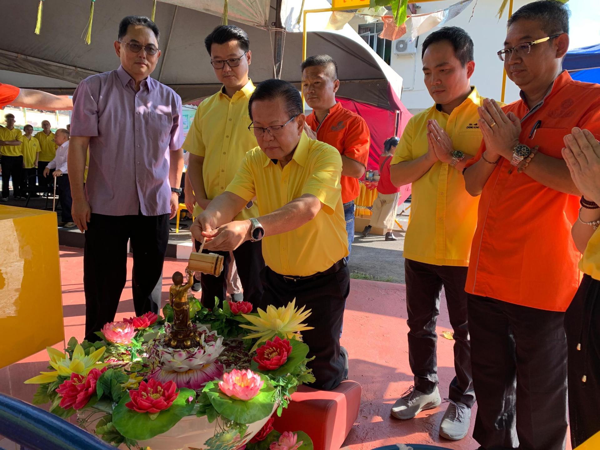 砂交通部长拿督斯里李景胜进行浴佛时影。后排左2为刘奕杰市议员、右1为主席温武平、右2为张嵻铭。
