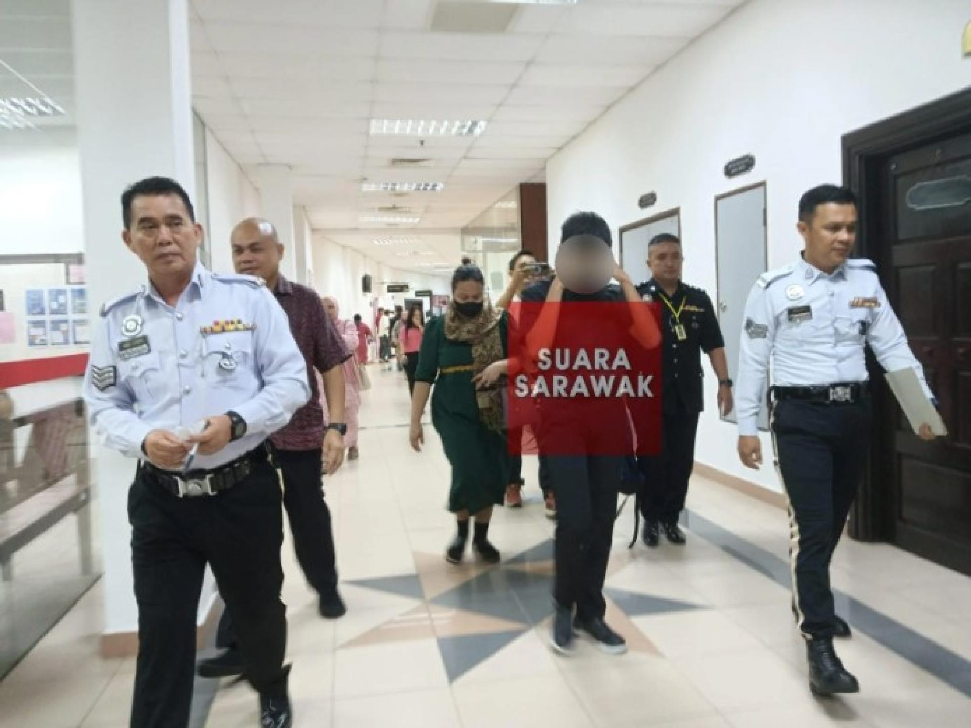 少年在交警陪同下离开治安法庭，前往支付保释金。