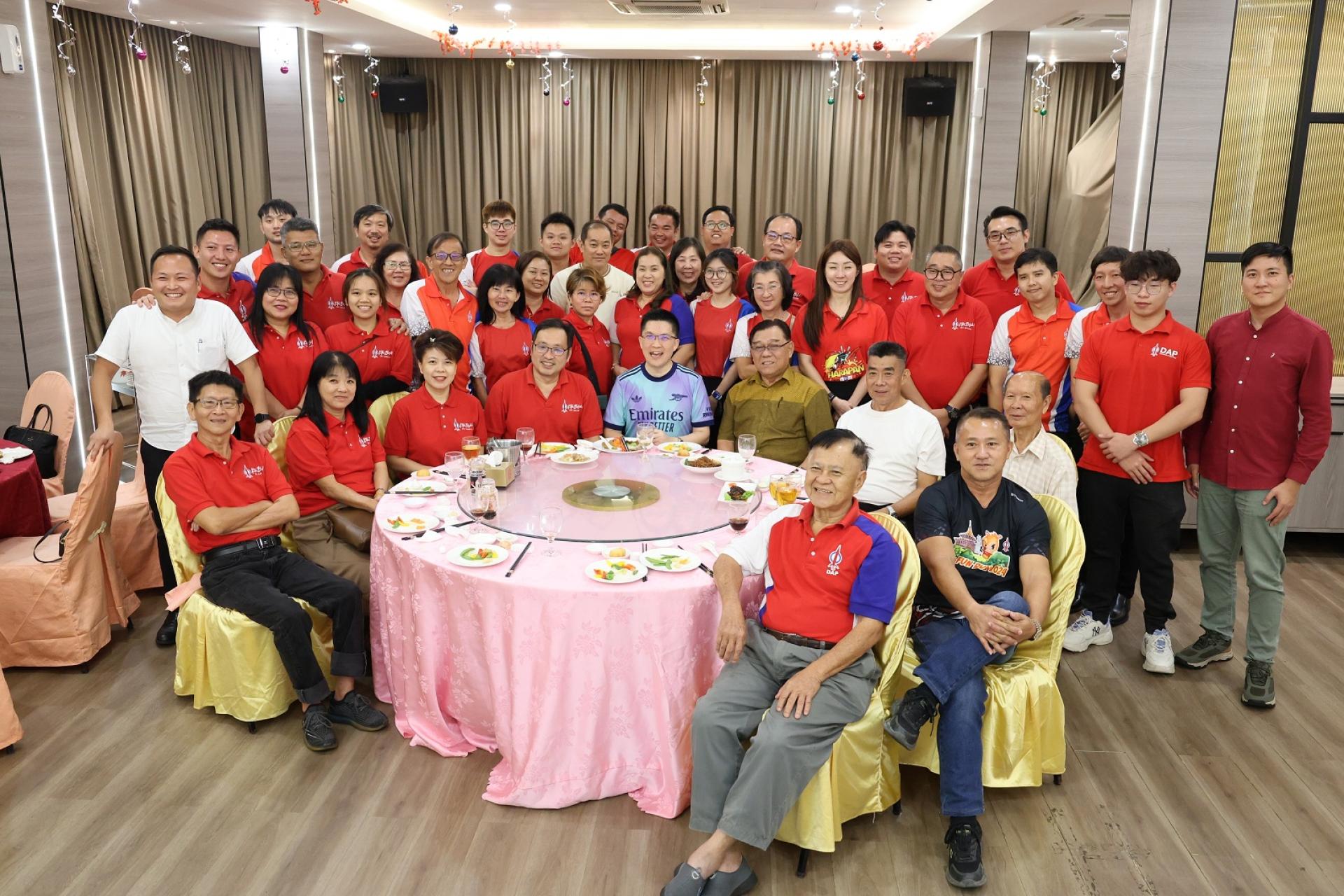 古晋行动党党员与副部长黄家和（坐者左5）聚餐合影。坐者左3起为朋岭区州议员兼砂行动党组织秘书杨薇讳、砂行动党主席兼国州议员张健仁及周政新等。