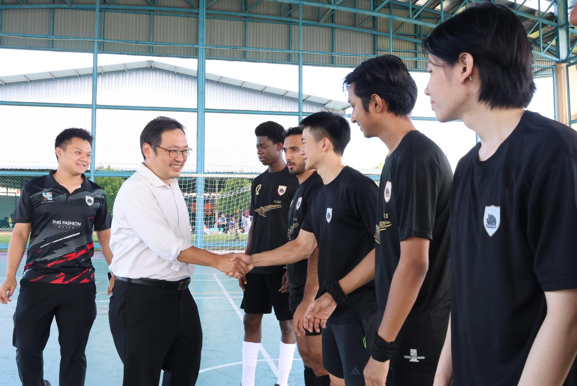 实旦宾区国会议员张健仁（左2）与参赛队伍握手。左1为Swinburne Sarawak Fustal & Football Club会长林楷斌。