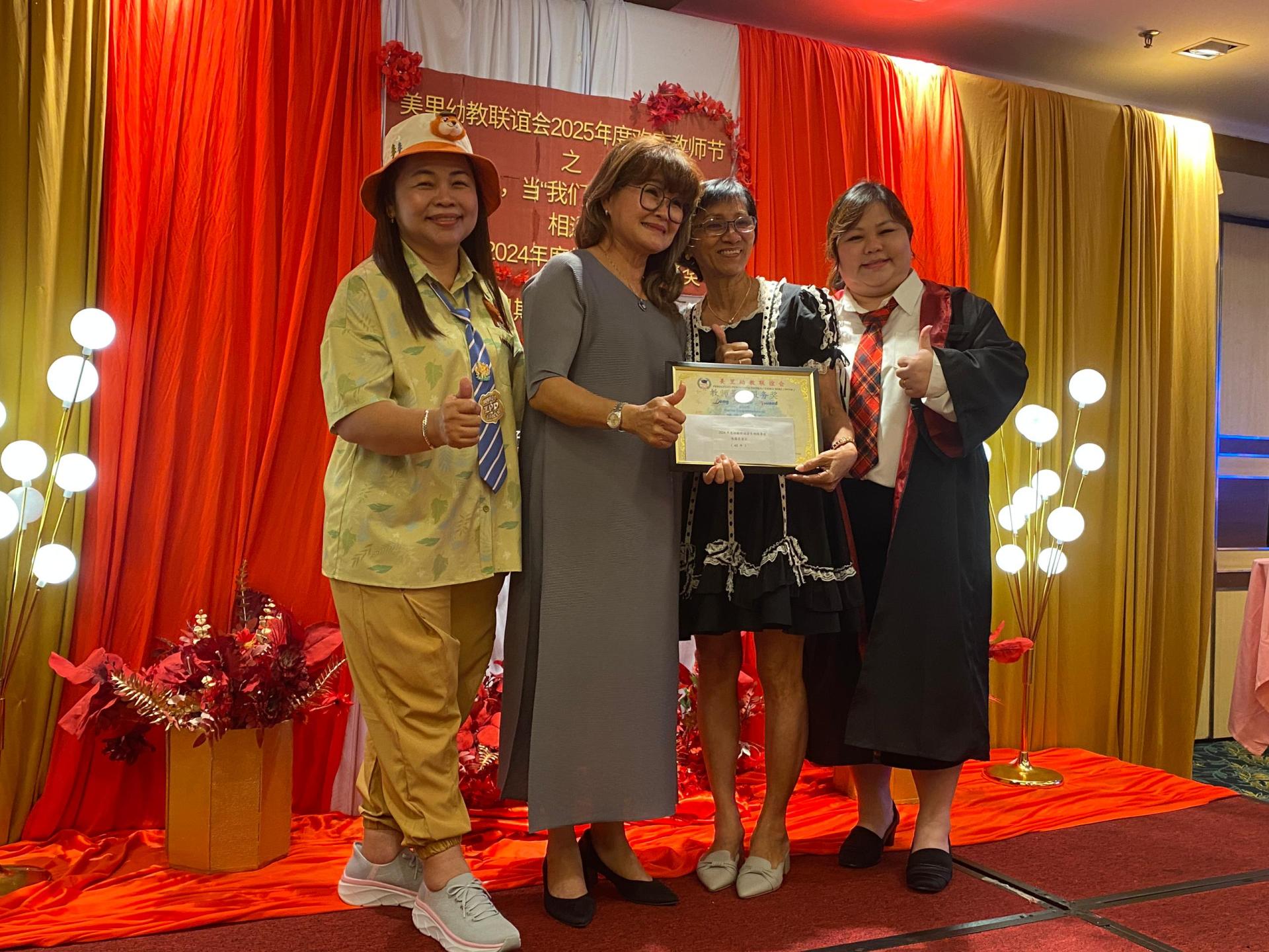 甲必丹余继香（左2）颁奖予荣获43年服务奖的陈葆花园  长合影。左为美里幼教联谊会主席沈秀芳。