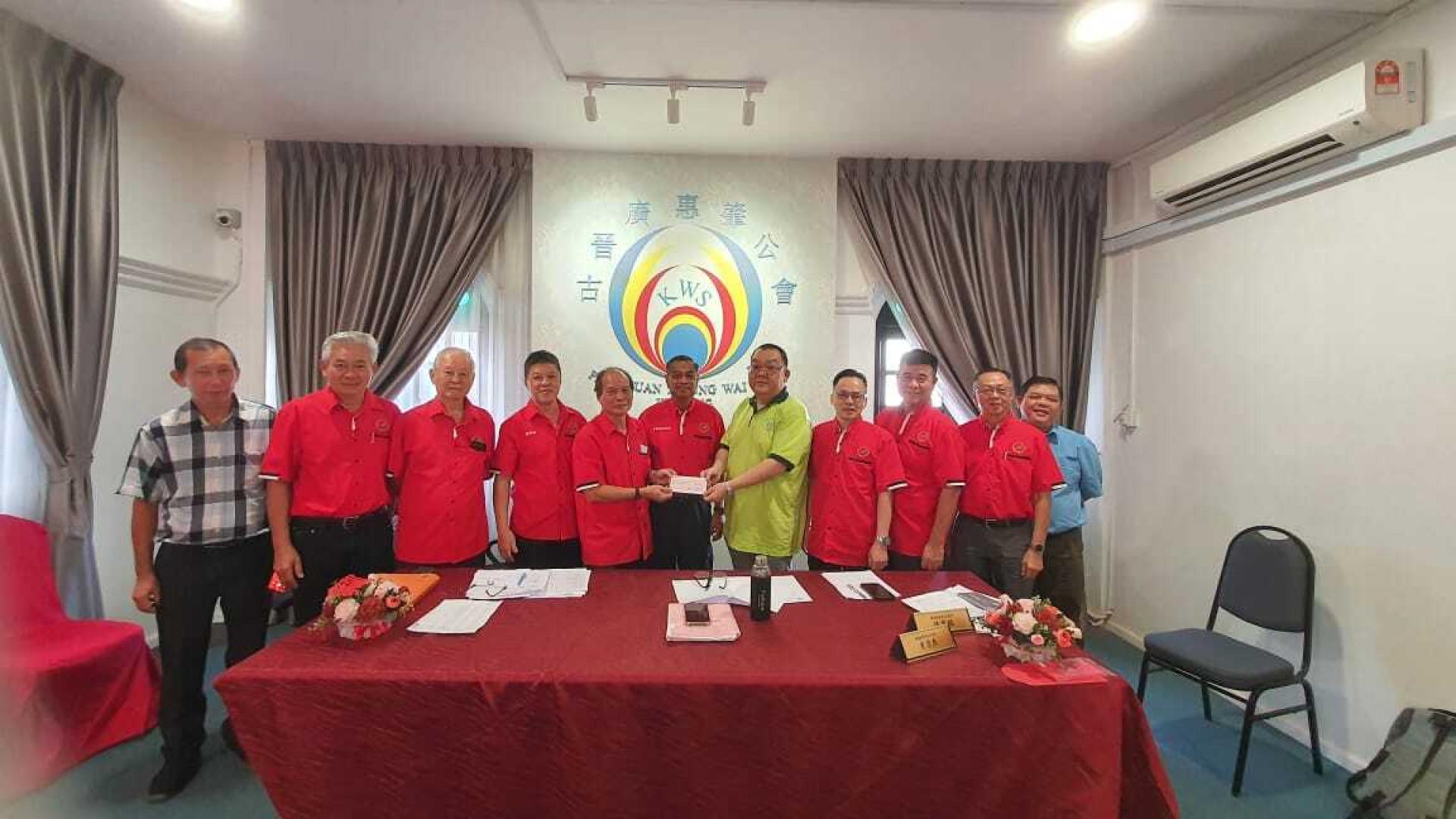 砂拉越广东乡团联合会财政潘政善(左5)移交捐款给古晋广惠肇公会副主席林宗利。中为砂广惠肇乡团会长甘保祥。