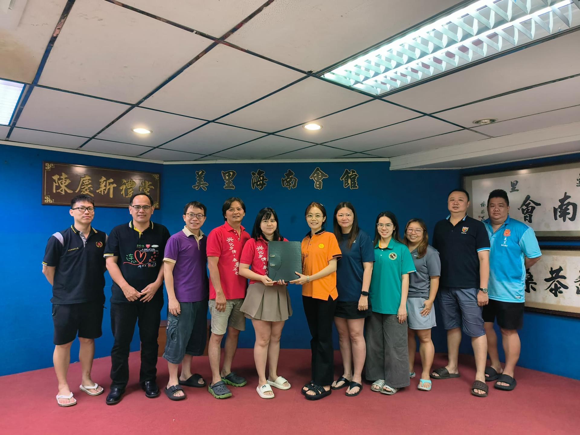 美里兴青团财政黄慧怡（左5）代表移交联合财政职权予美里潮青团财政郑佳欣。左起为埔青团  活动策划朱景兴、客青团团长杨万勇、广青团长余伟顺、兴青团团长蔡裕忠；右起为河青团副团长黄义熙、诏  青团团长许伟强、榕青团秘书范文琦、海南青团团长陈敏慧及潮青团署理团长谢慧芬。