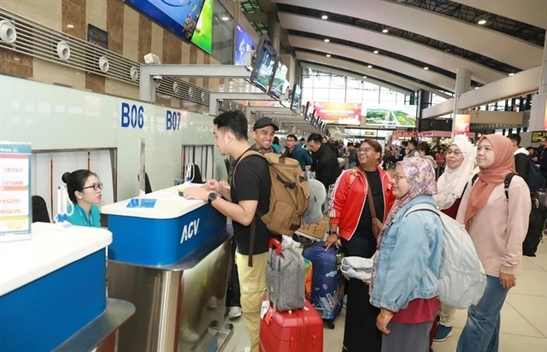 旅客排队办理登机手续，地点为河内的内牌国际机场。