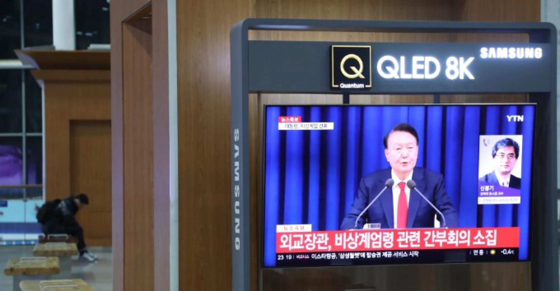 韩国首尔火车站的电视上播放总统宣布紧急戒严令的画面。
